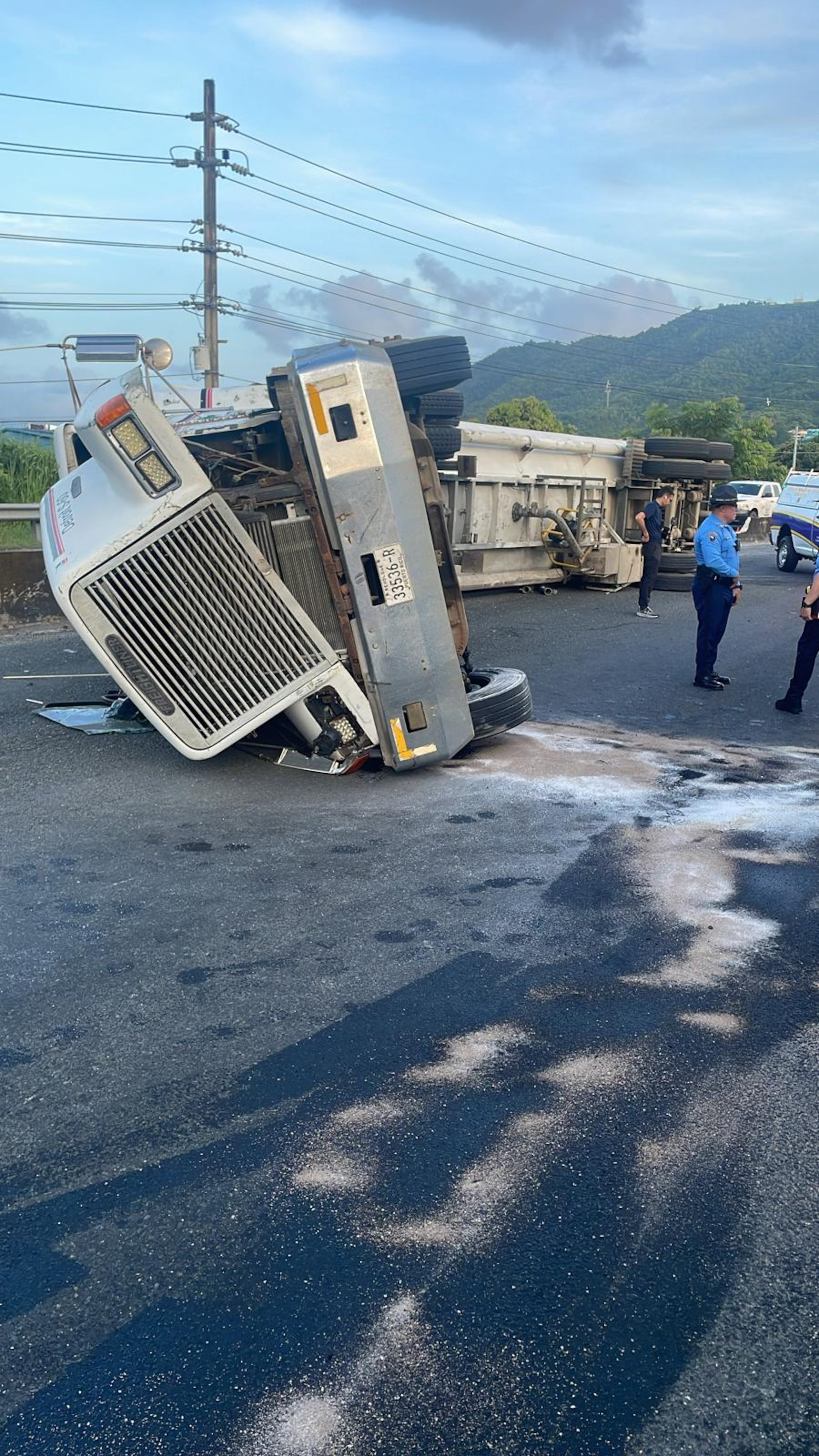 Imagen de un camión que transitaba por la carretera PR-1 en dirección hacia la PR-30 e impactó la barrera de hormigón volcándose y obstruyendo el tránsito en la salida hacia la autopista Luis A. Ferré.