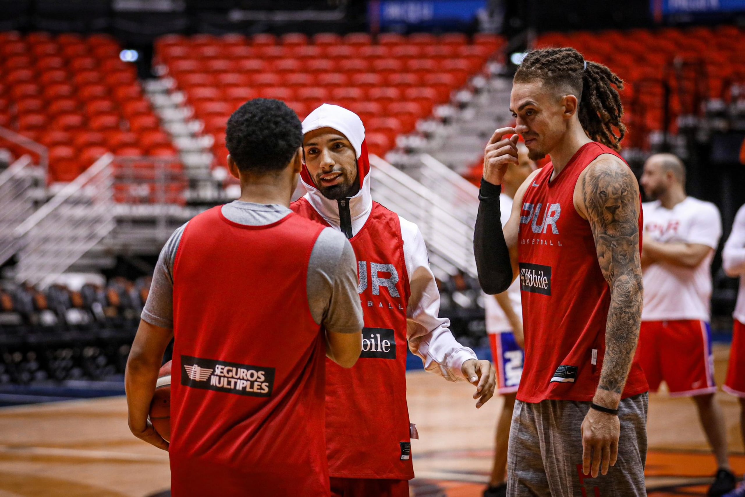 José Alvarado saluda a Tremont Waters a su entrada a la cancha para su primera práctica de cara al torneo. Les observan Isaiah Piñeiro.