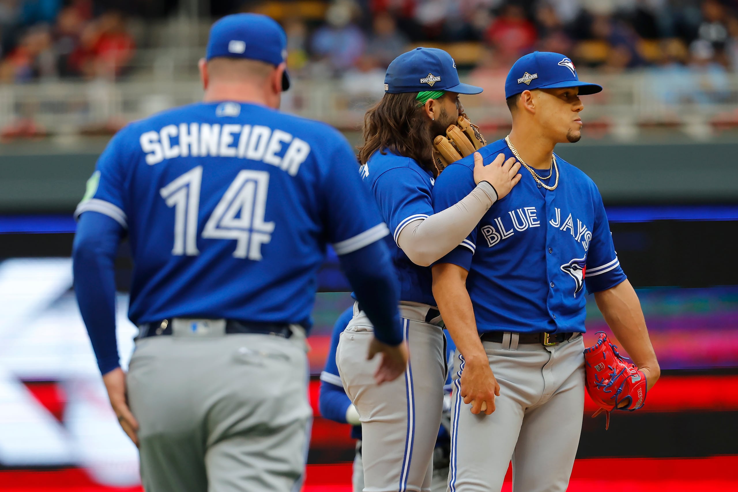 José Berríos y Bo Bichette esperan al mánager John Schneider, mientras este se dirigía al montículo, en el partido de comodín entre los Blue Jays y Twins.