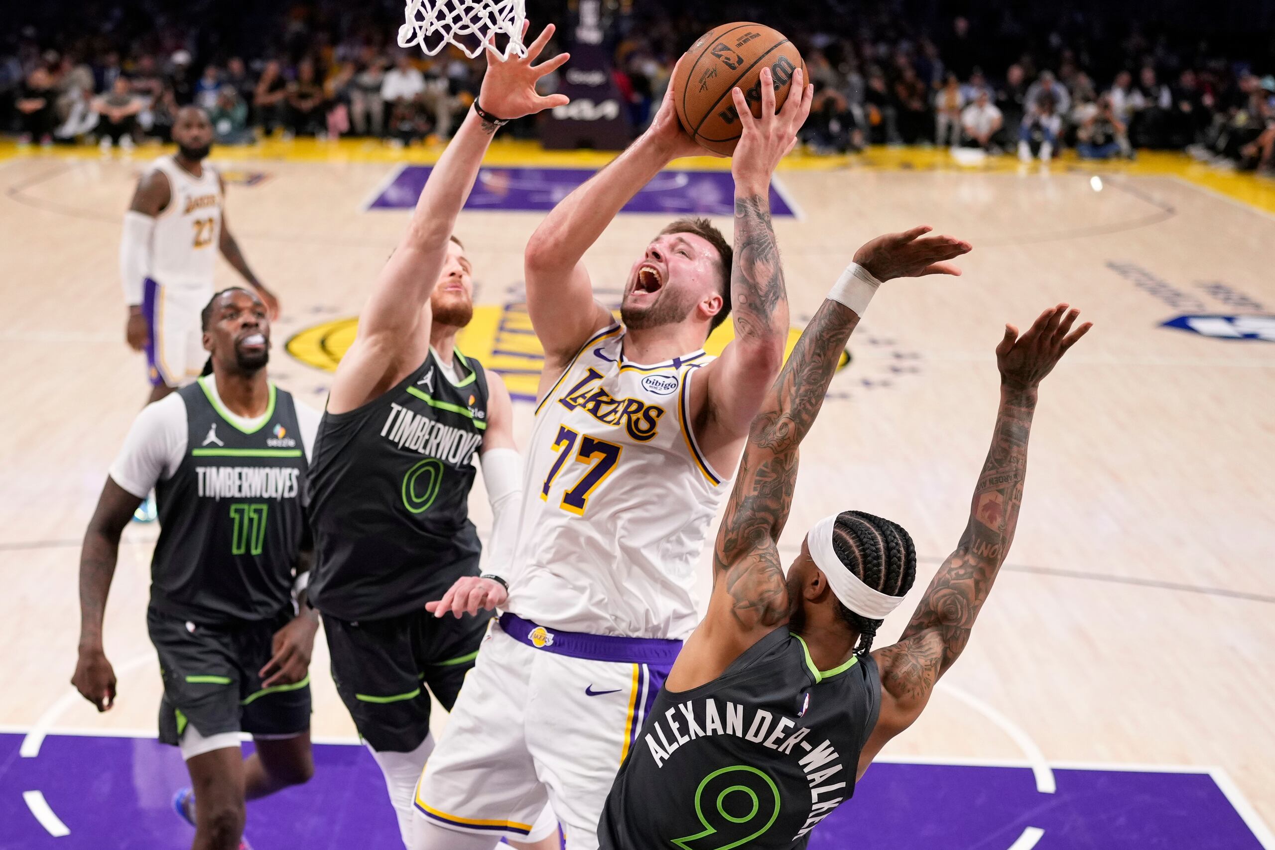 Luka Doncic, de los Lakers de Los Ángeles, lanza un canasto ante la defensa de los Timberwolves de Minnesota.