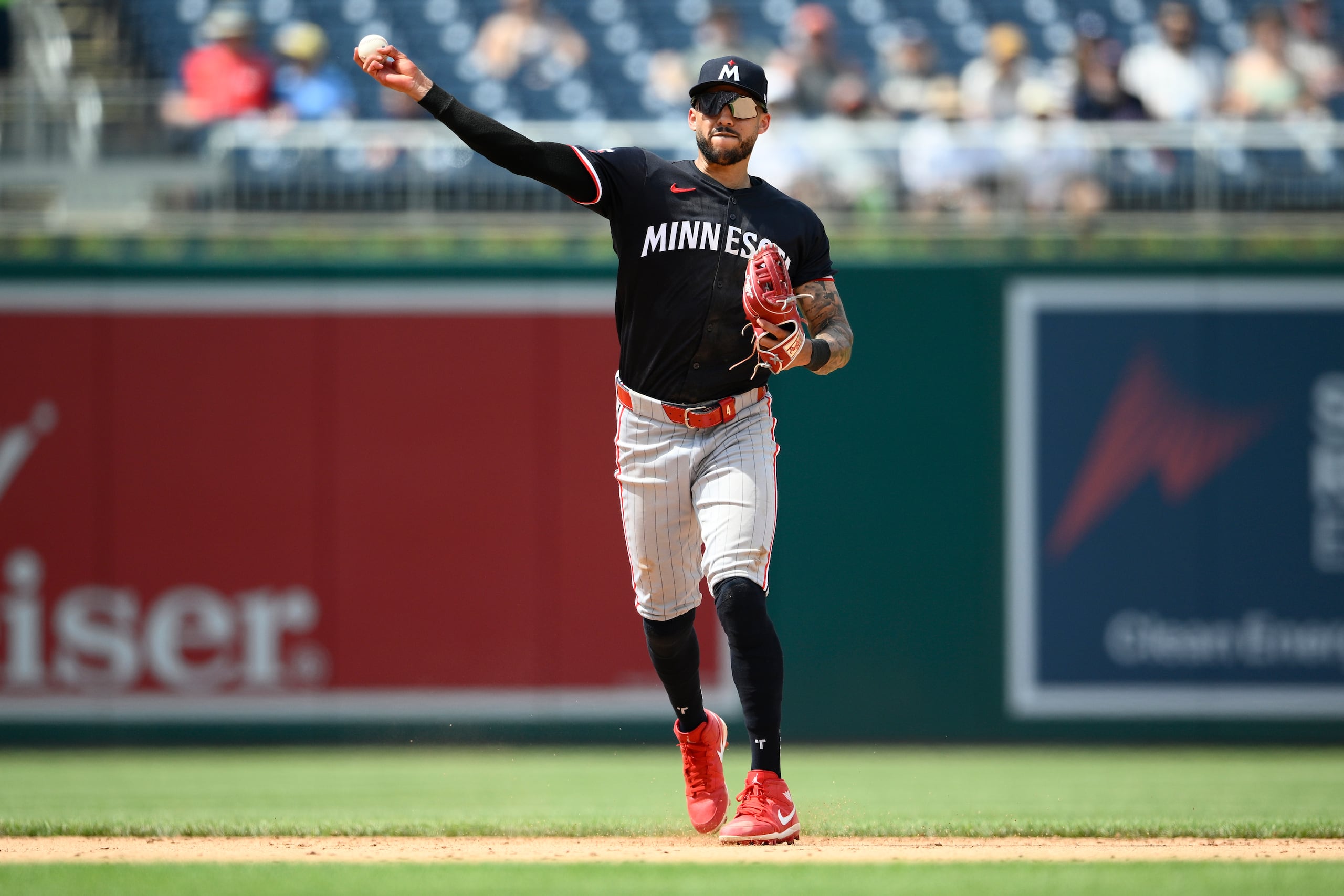 Carlos Correa, de los Twins de Minnesota, saca de out a Nick Senzel, de los Nationals de Washington.