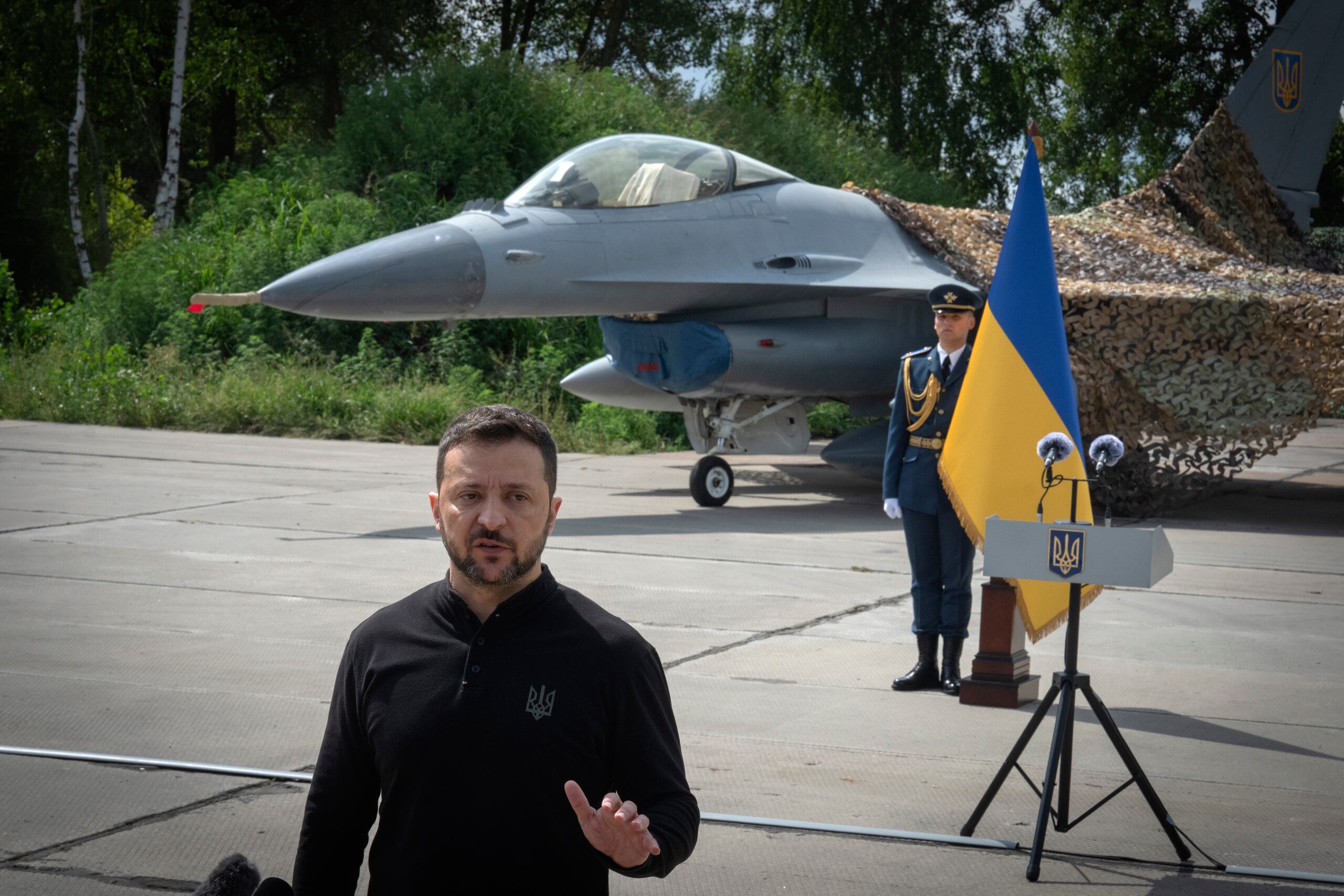 El presidente ucraniano, Volodymyr Zelenskyy, responde preguntas de los medios frente a los aviones de combate F-16 de la Fuerza Aérea ucraniana, en un lugar no revelado de Ucrania, el domingo 4 de agosto de 2024. (AP Foto/Efrem Lukatsky)