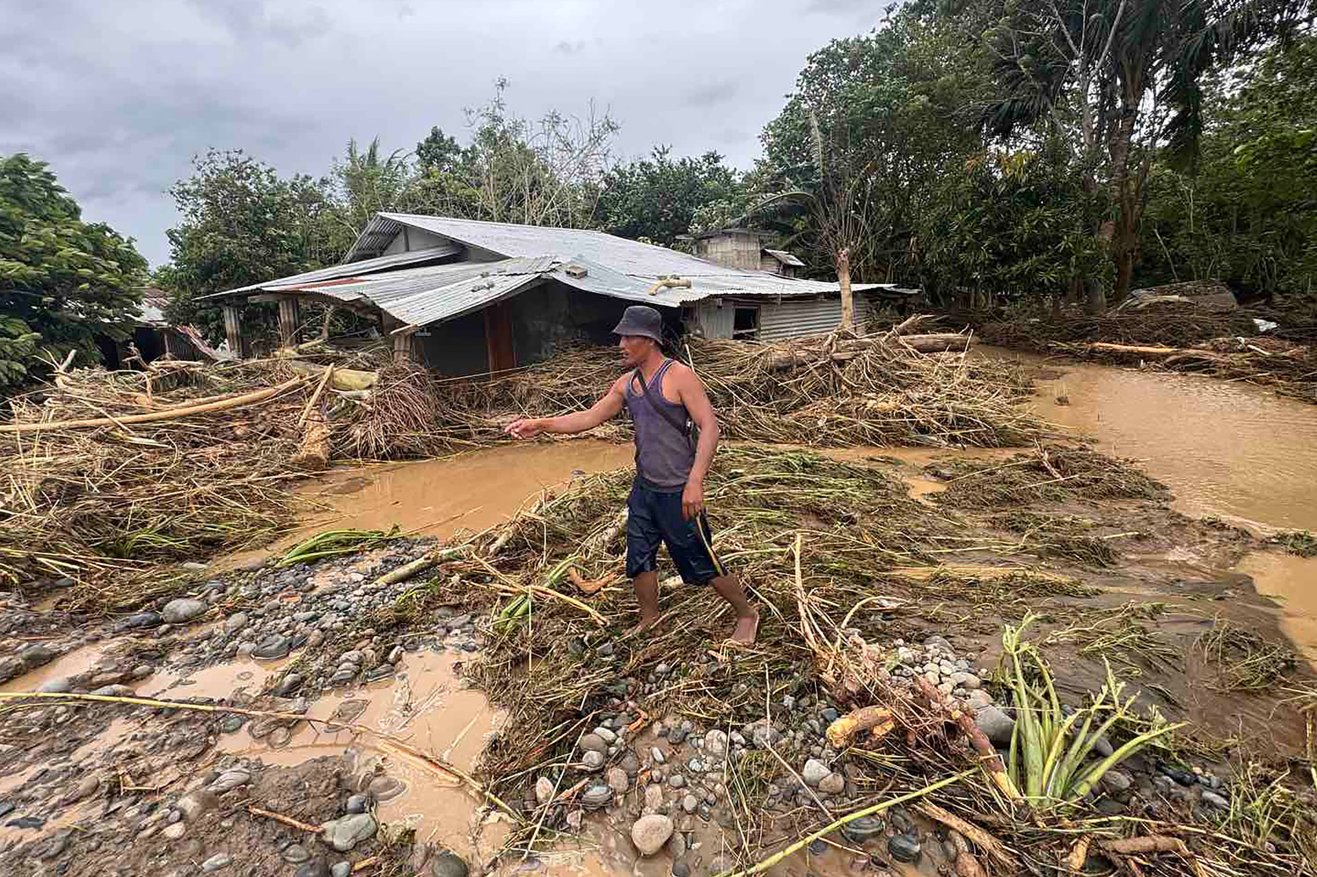 A resident inspects his house after it was inundated by floodwaters in Tuao town, Cagayan province, on November 10, 2025, after a river overflowed due to heavy rains brought by Super Typhoon Fung-wong. Entire villages lay submerged and scores of towns remained without electricity on November 10 as Typhoon Fung-wong left the Philippines after killing at least two people and displacing more than a million. (Photo by John Dimain / AFP)