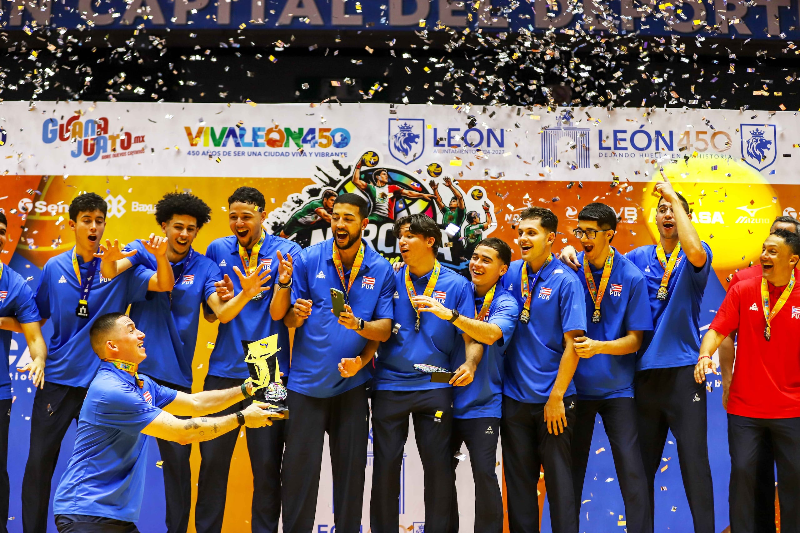 El capitán Árnel Cabrera levanta la copa al frente de sus compañeros de equipo de la Selección Nacional en la ceremonia de premiación del Final Four de Norceca jugado en México.
