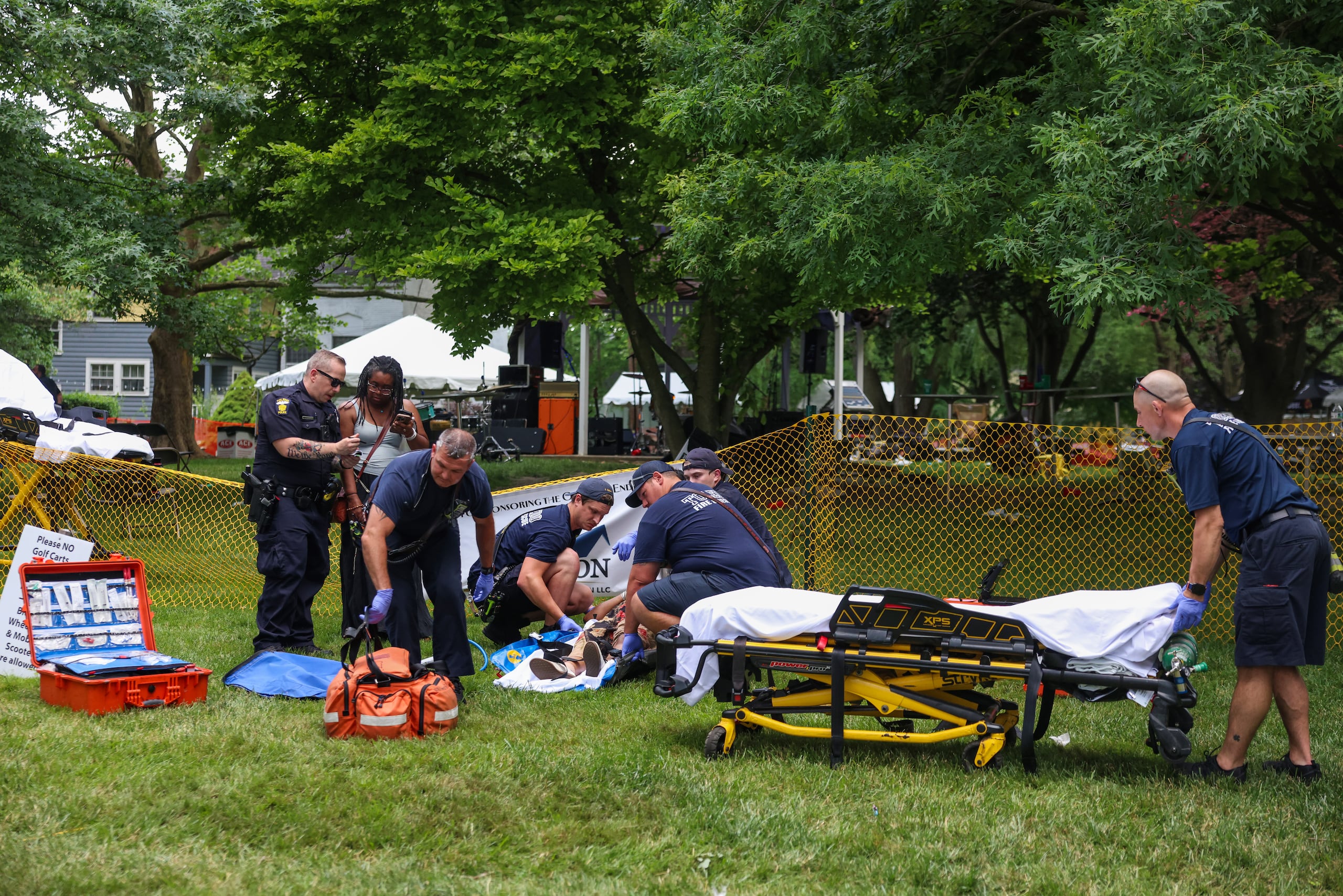 Equipos de emergencia auxilian a una mujer herida en el tiroteo masivo que dejó 12 personas lesionadas durante el festival Old West End, en el Agnes Reynolds Jackson Arboretum de Toledo, el sábado 6 de junio de 2026. (Rebecca Benson/The Blade vía AP)