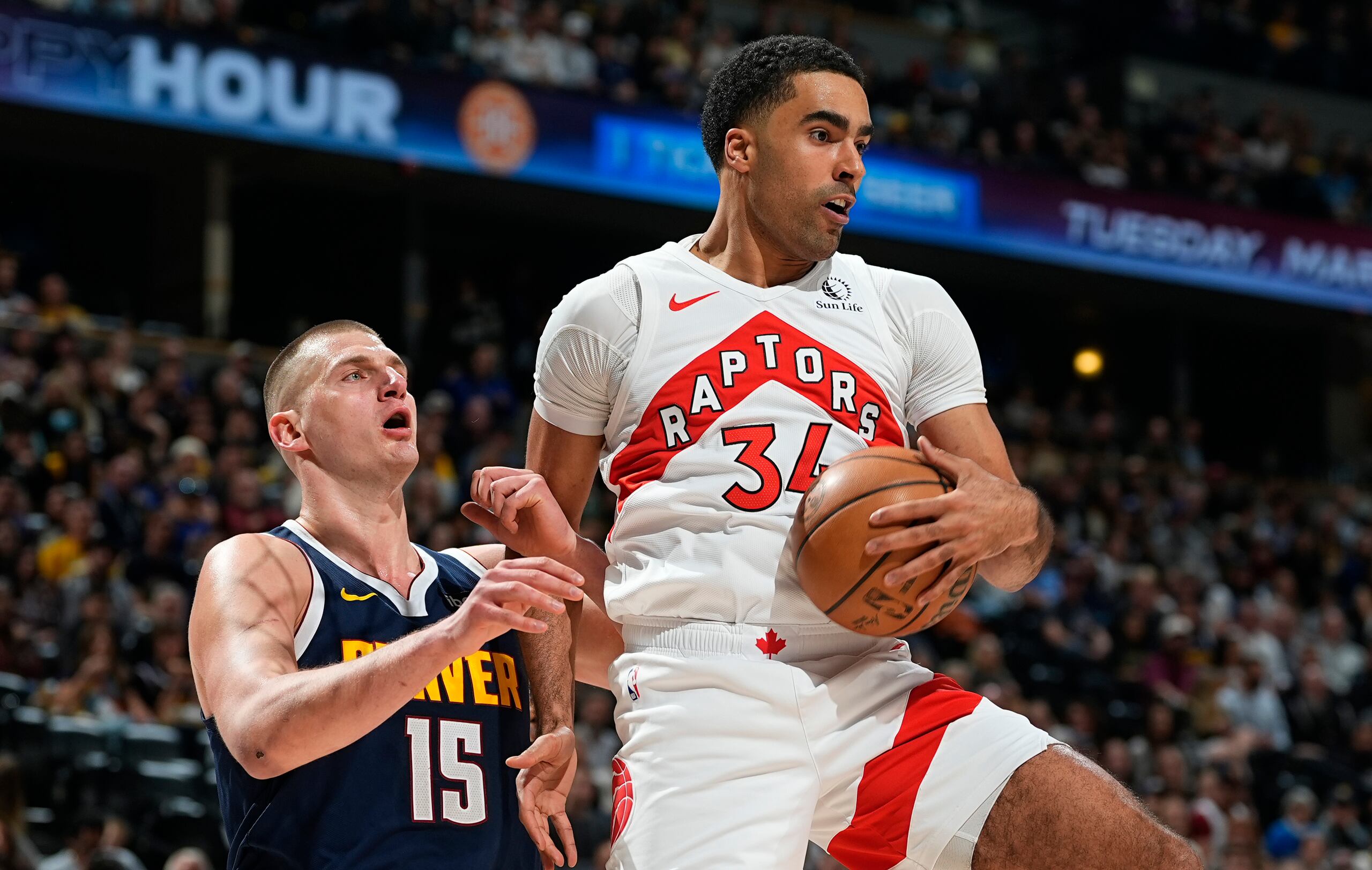 Jontay Porter, derecha, de los Raptors de Toronto, descuelga un rebote frente a Nikola Jokic, de los Nuggets de Denver.
