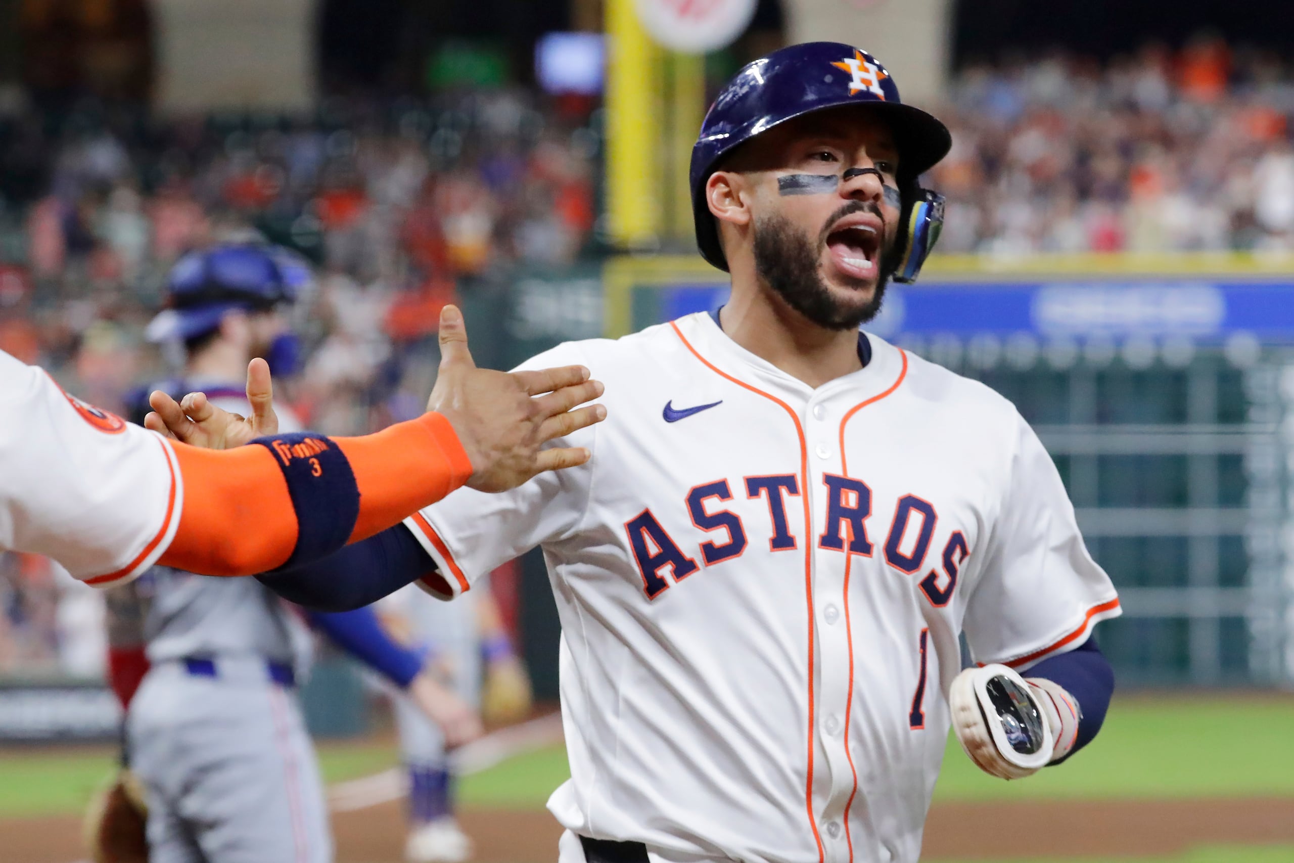 Carlos Correa, de los Astros de Houston, celebra después de anotar una carrera frente a los Rangers de Texas.