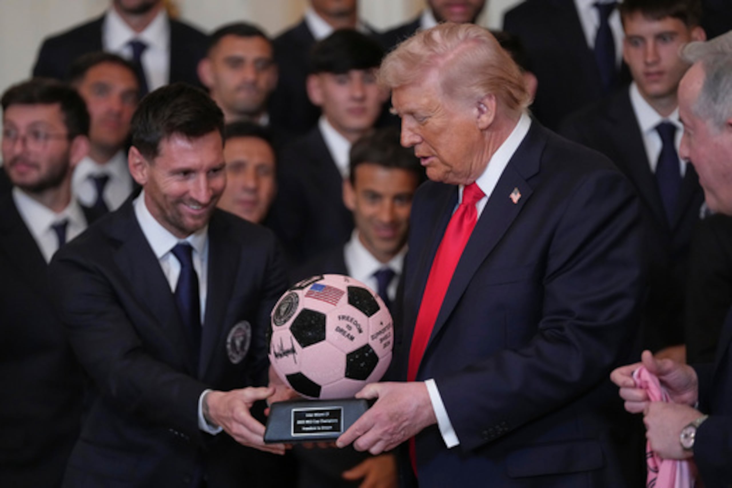 El presidente Donald Trump recibe un trofeo de balón de fútbol de manos de Lionel Messi durante un acto en honor al Inter de Miami, campeón de la Major League Soccer en 2025, en la Sala Este de la Casa Blanca, el jueves 5 de marzo de 2026, en Washington. (AP Photo/Julia Demaree Nikhinson)