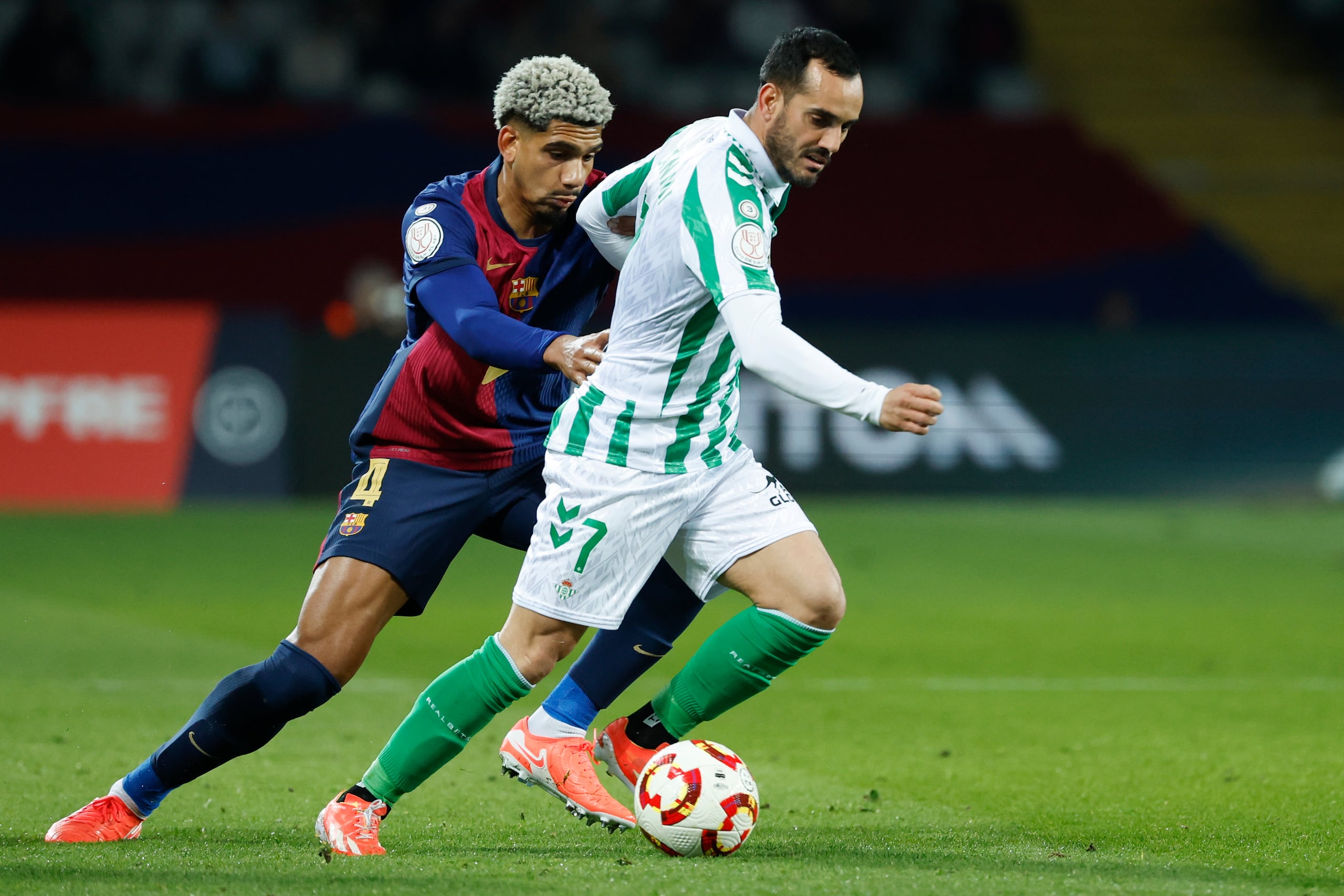 Ronald Araújo, a la izquierda, disputa el balón con Juanmi del Betis durante un partido de octavos de final de la Copa del Rey entre Barcelona y Real Betis en el Estadio Olímpico Lluis Companys en Barcelona, España
