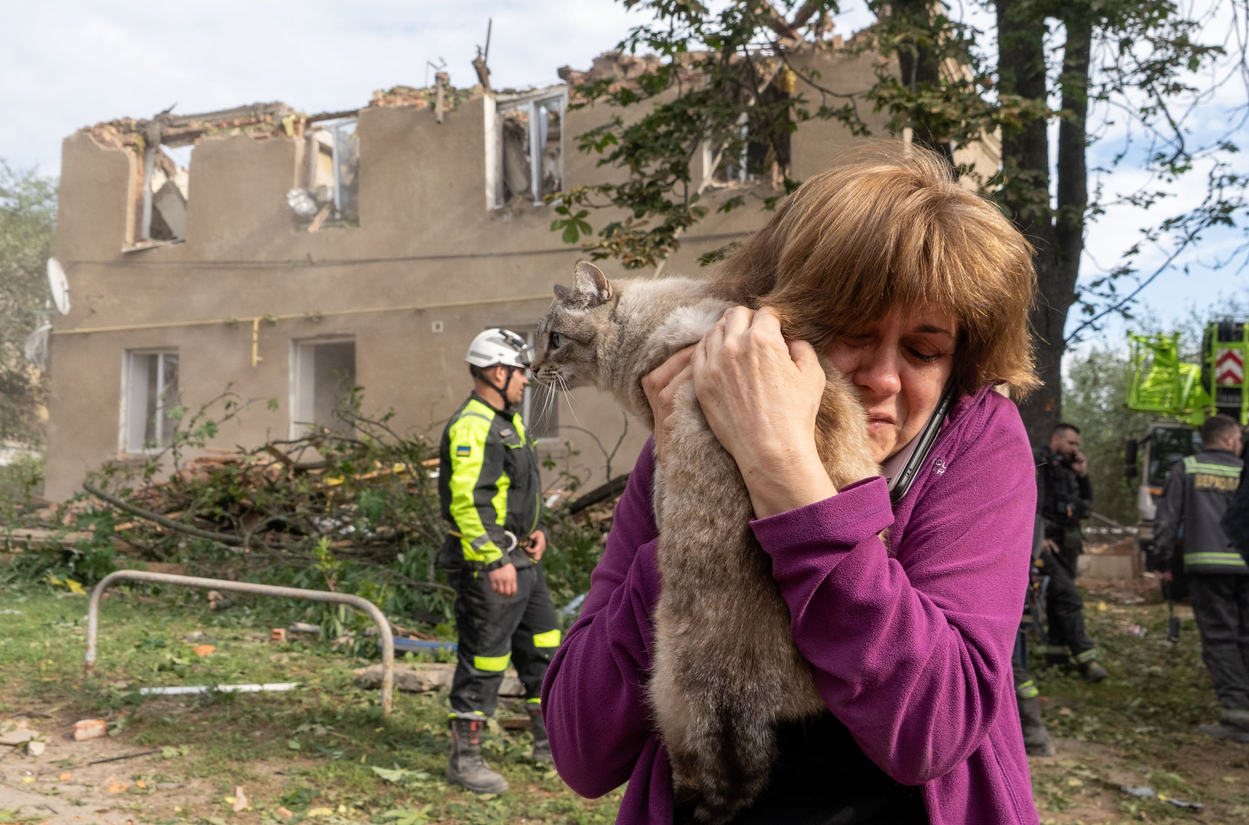Una mujer abraza a su gato tras encontrarlo durante las labores de rescate y búsqueda en un edificio residencial dañado por un ataque de misiles rusos en Járkiv, Ucrania, el sábado 20 de junio de 2026. (AP Foto/Andrii Marienko)