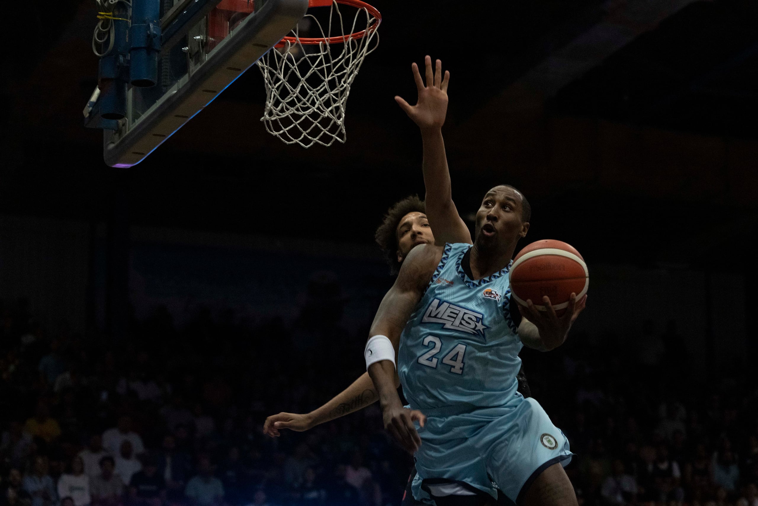 Rondae Hollis-Jefferson ataca el canasto ante la defensa de George Conditt IV, de los Gigantes de Carolina.