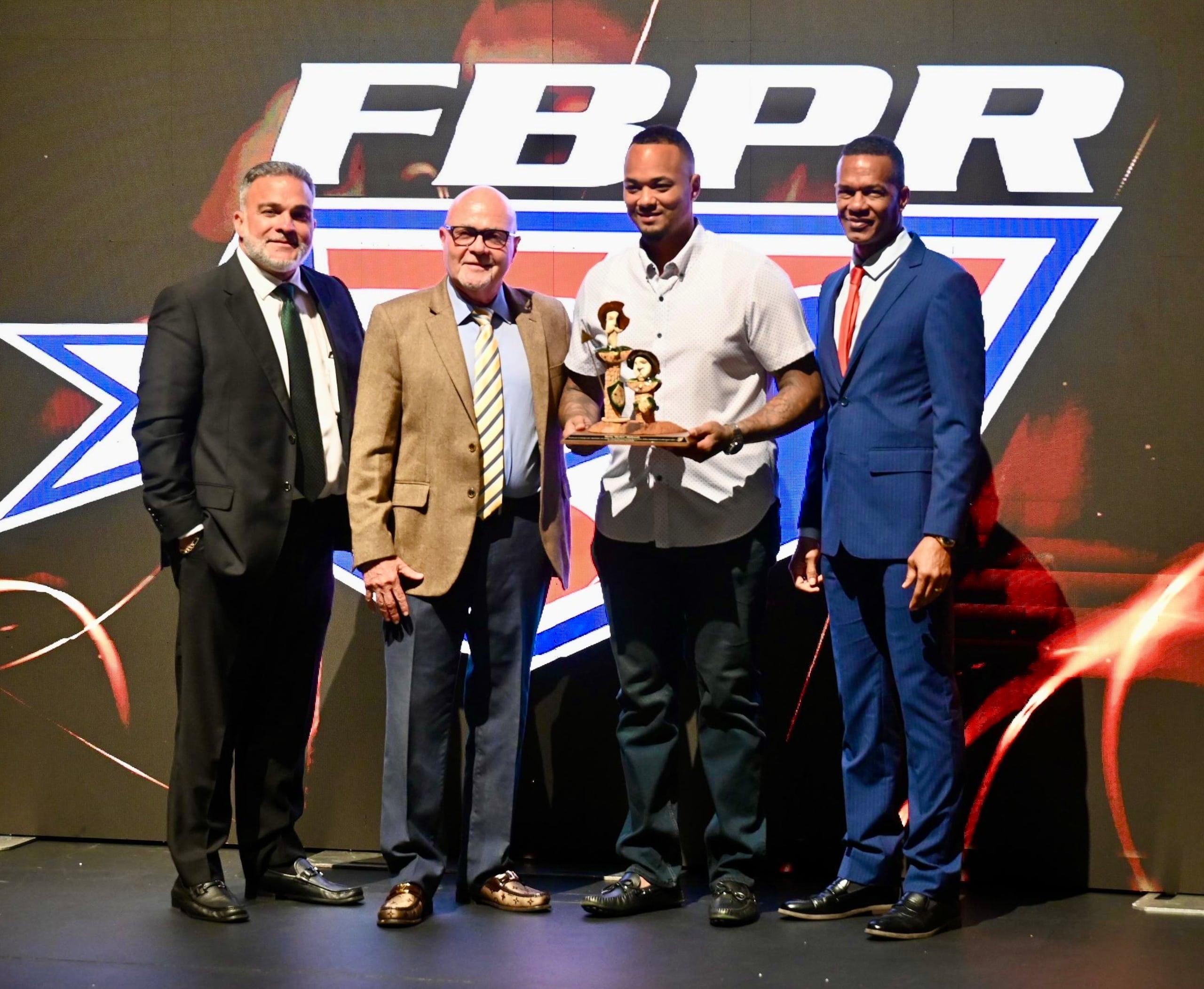 Martín Maldonado fue el orador invitado a la actividad y en la foto aparece sosteniendo un regalo que recibió de parte de los directivos de la Federación de Béisbol que aparecen a su lado.