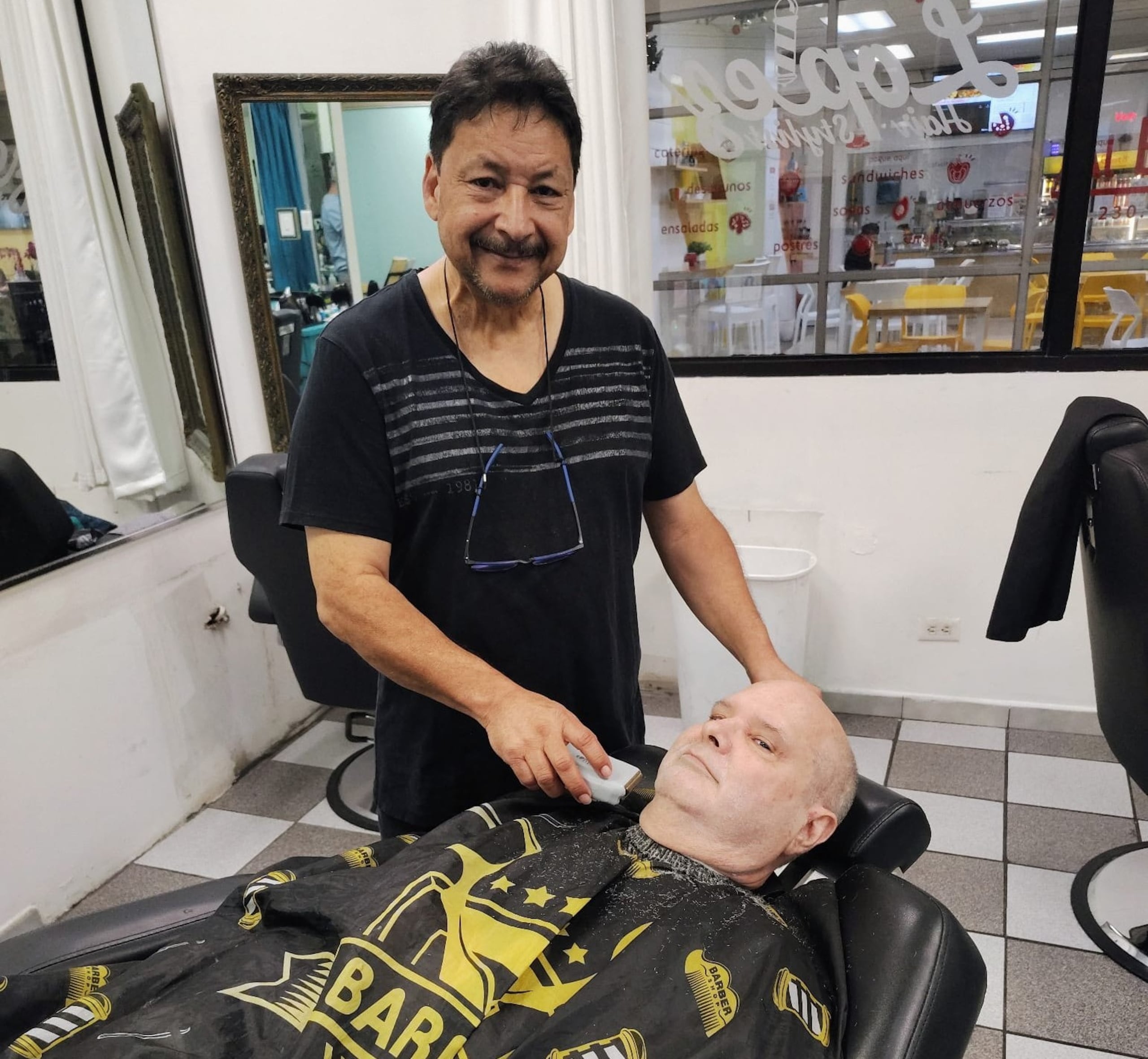 René Romero Reyes, de 65 años, atiende a un cliente en su barbería en Guaynabo.