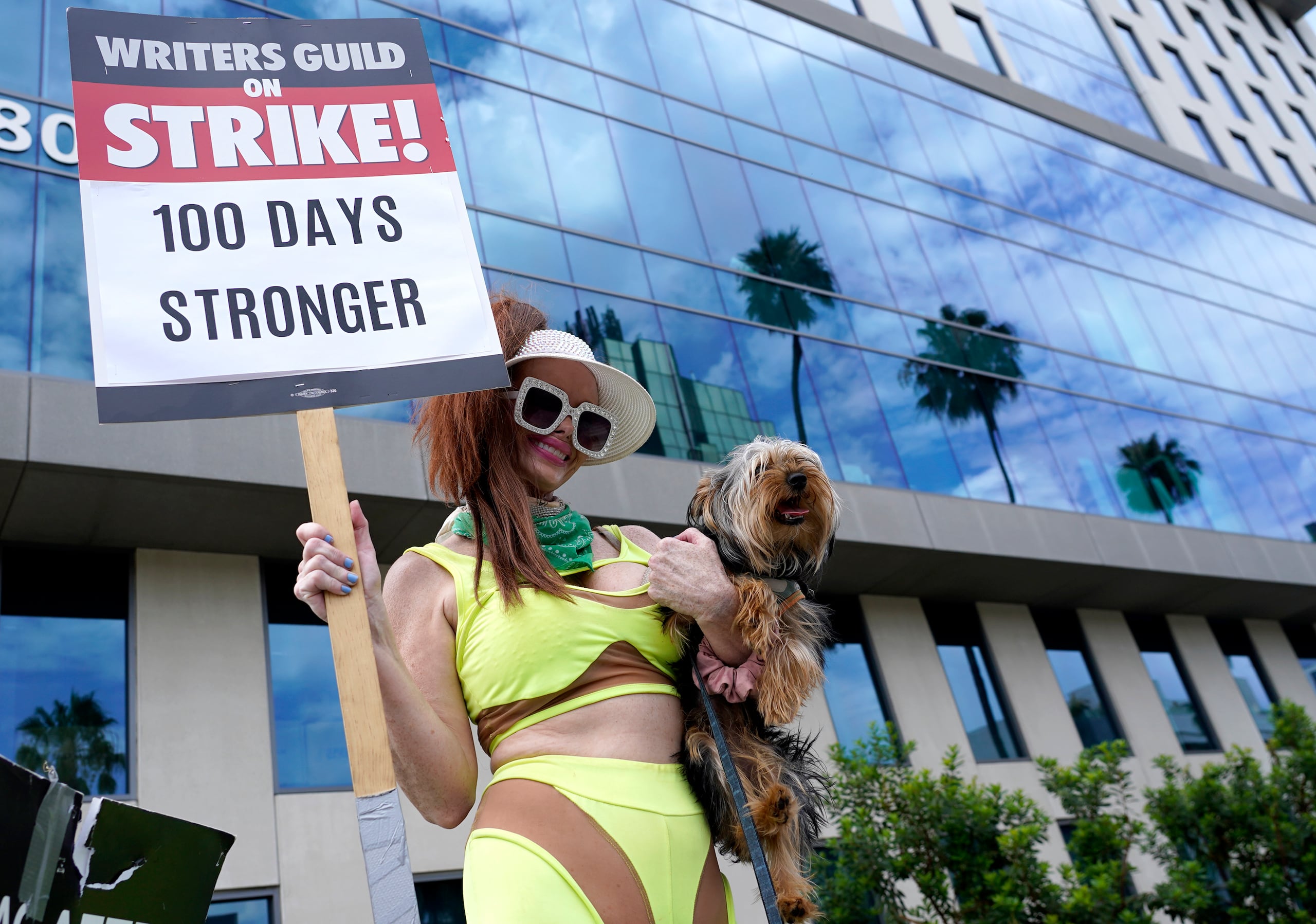 Phoebe Price lleva a su perro Arnold junto con un cartel en una protesta frente a los estudios de Netflix el miércoles 9 de agosto de 2023 en Los Ángeles.