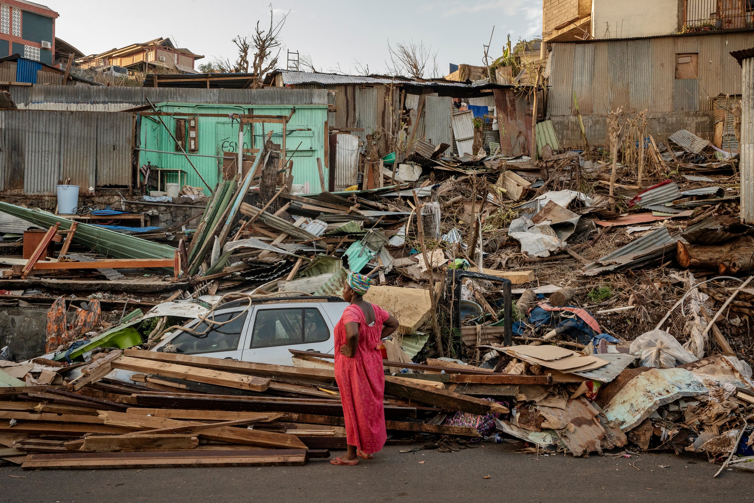 Una mujer observa una casa destruida en Mamoudzou, Mayotte, el jueves 19 de diciembre de 2024. (AP foto/Adrienne Surprenant)