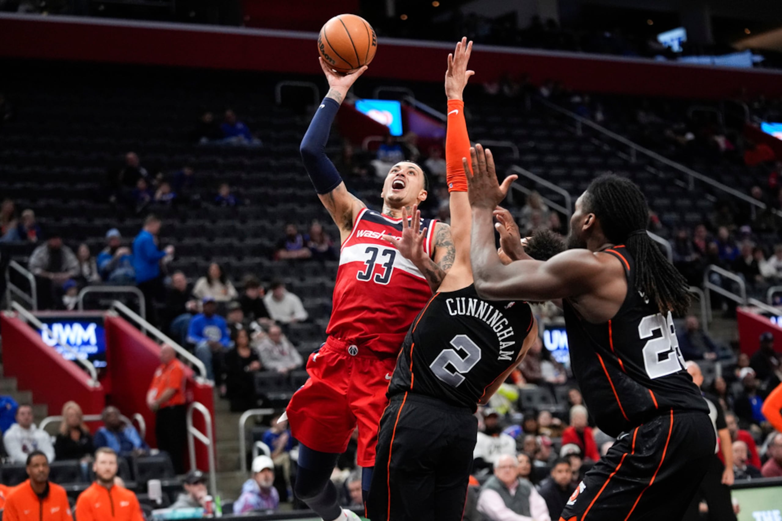 El alero de los Wizards de Washington Kyle Kuzma avanza hacia la canasta mientras lo defiende el base de los Pistons de Detroit Cade Cunningham.