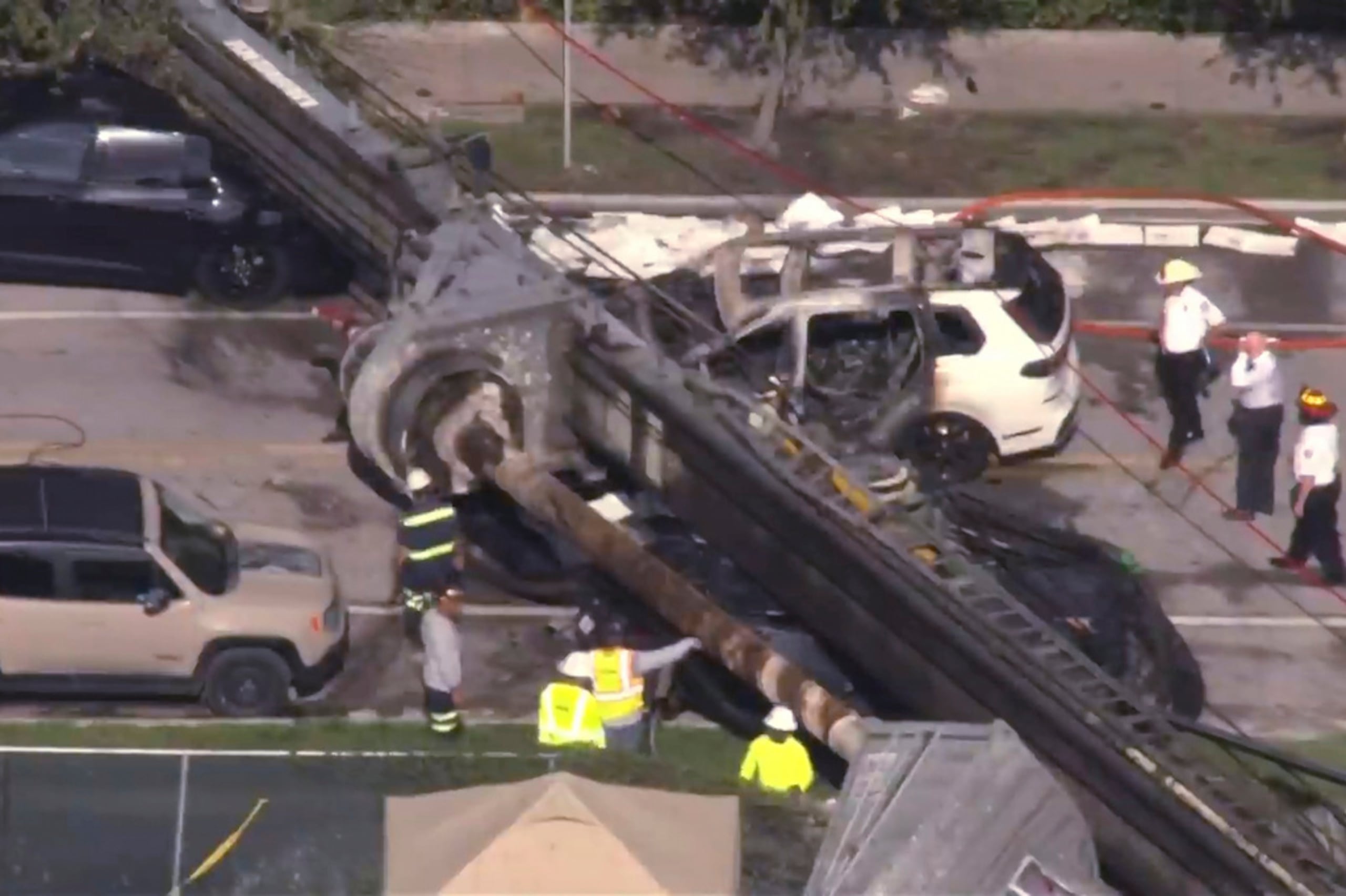 Esta imagen, tomada de un video de WSVN, muestra un vehículo aplastado luego de que una grúa colapsara en una obra de construcción en Miami el lunes 14 de septiembre de 2026.