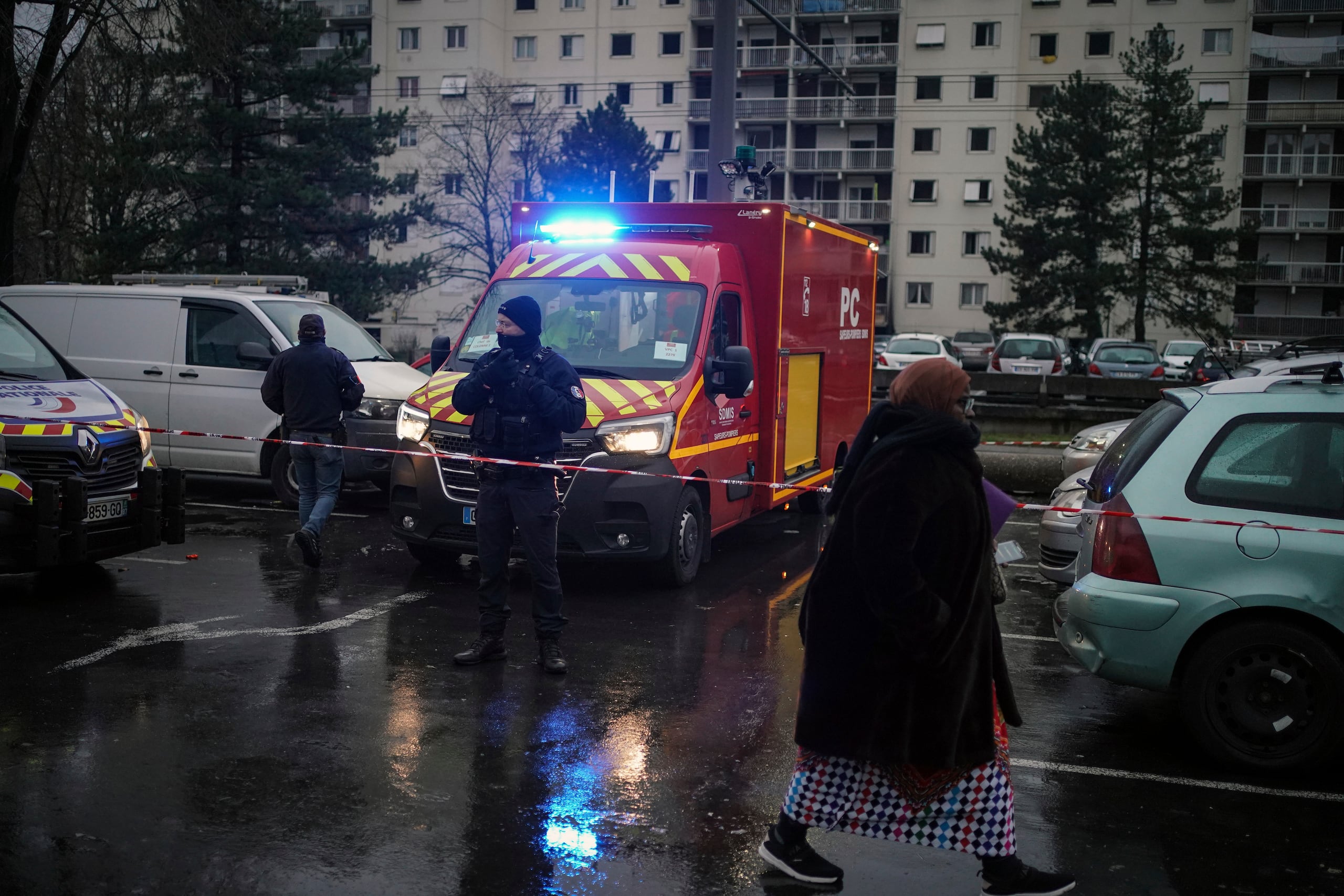 Un agente de policía hace guardia junto a un camión de bomberos tras un incendio en un edificio en el vecindario Le Mas du Taureaum, en Vauls en Velin, a las afueras de Lyon, Francia.