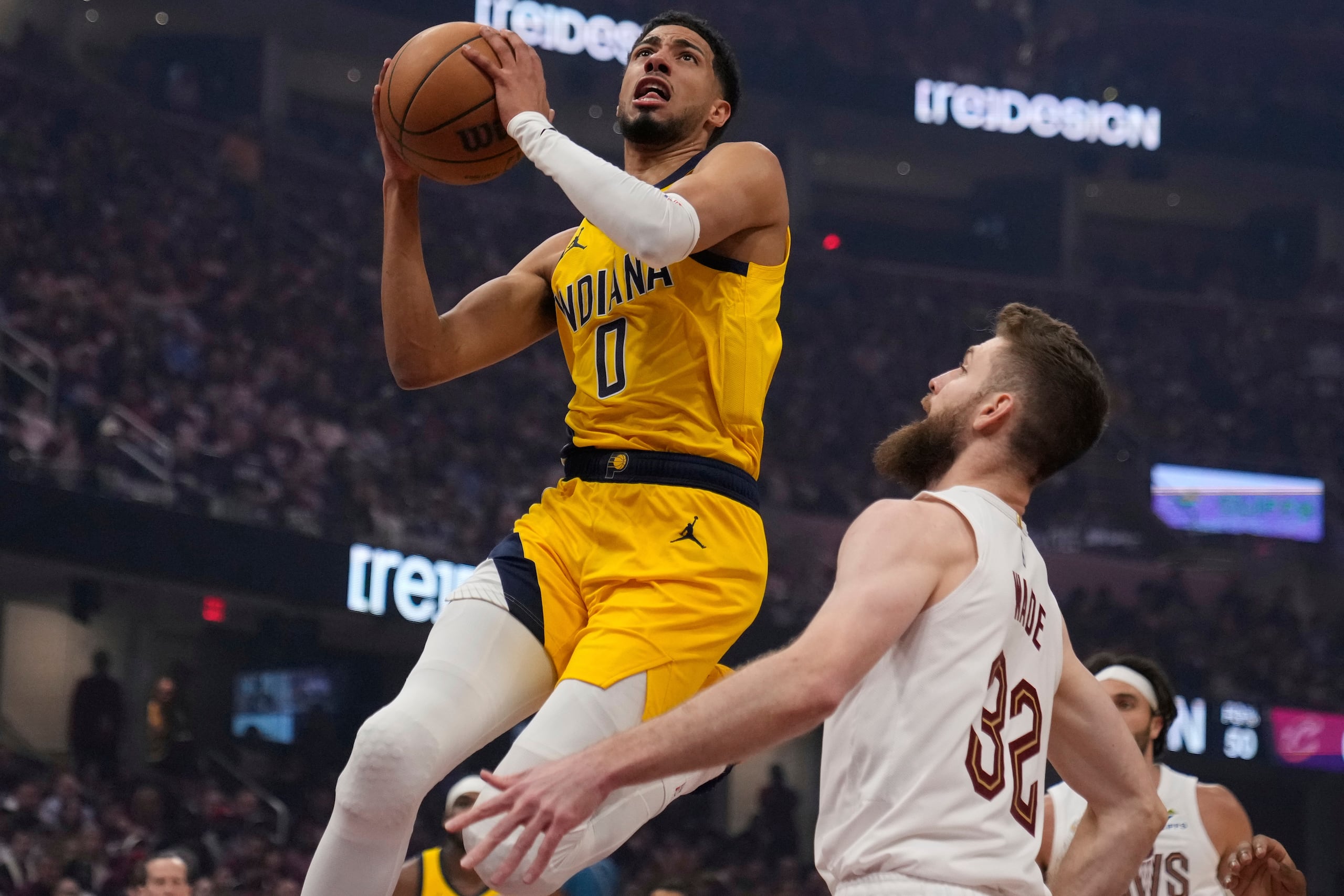 Tyrese Haliburton (0), de los Pacers de Indiana, ataca la canasta frente Dean Wade (32), de los Cavaliers de Cleveland, en la primera mitad del primer juego de las semifinales de la Conferencia Este del baloncesto de la NBA, el domingo 4 de mayo de 2025, en Cleveland. (AP Foto/Sue Ogrocki)
