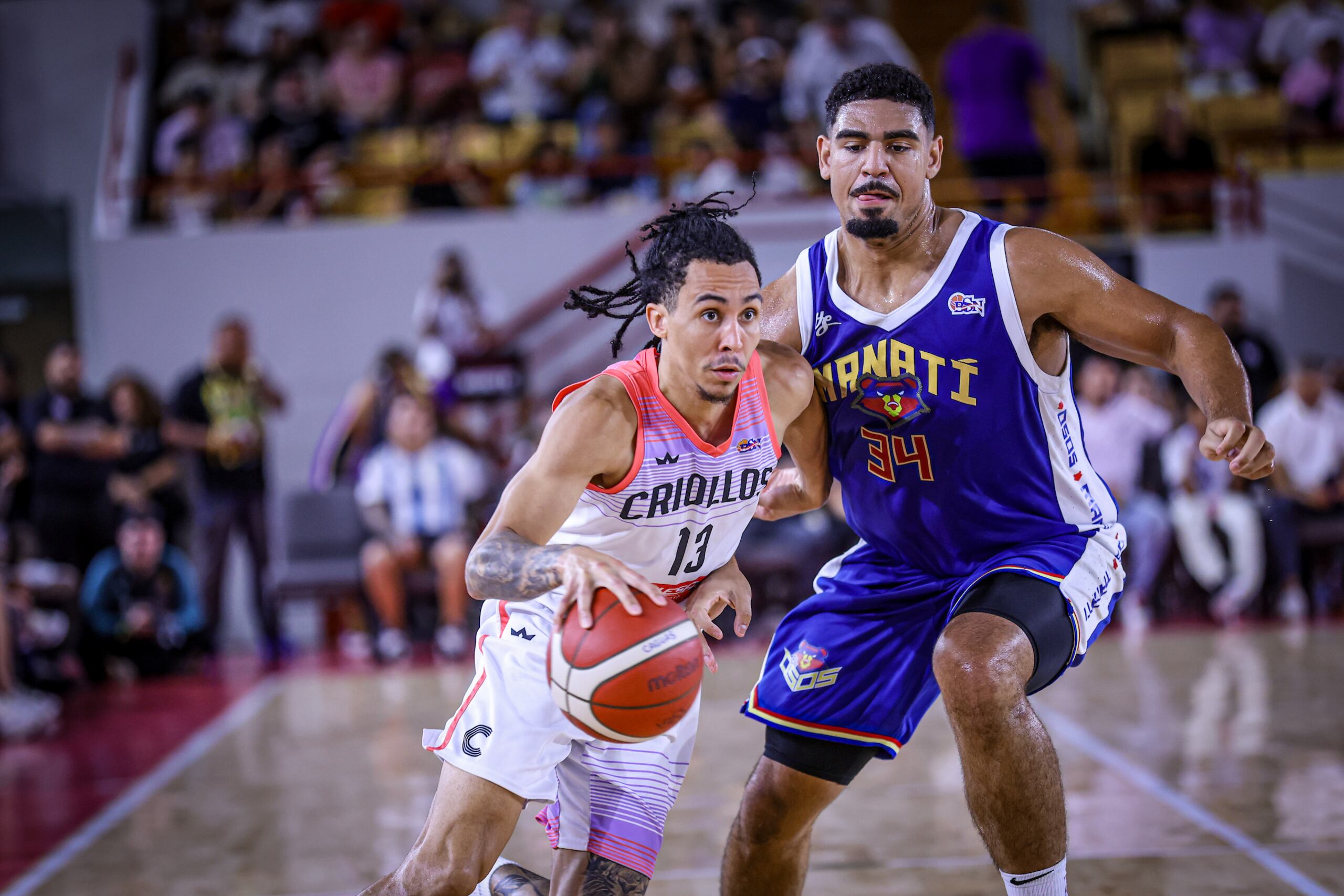 Travis Trice, de los Criollos de Caguas, maneja el balón ante Tyler Davis, de los Osos de Manatí.