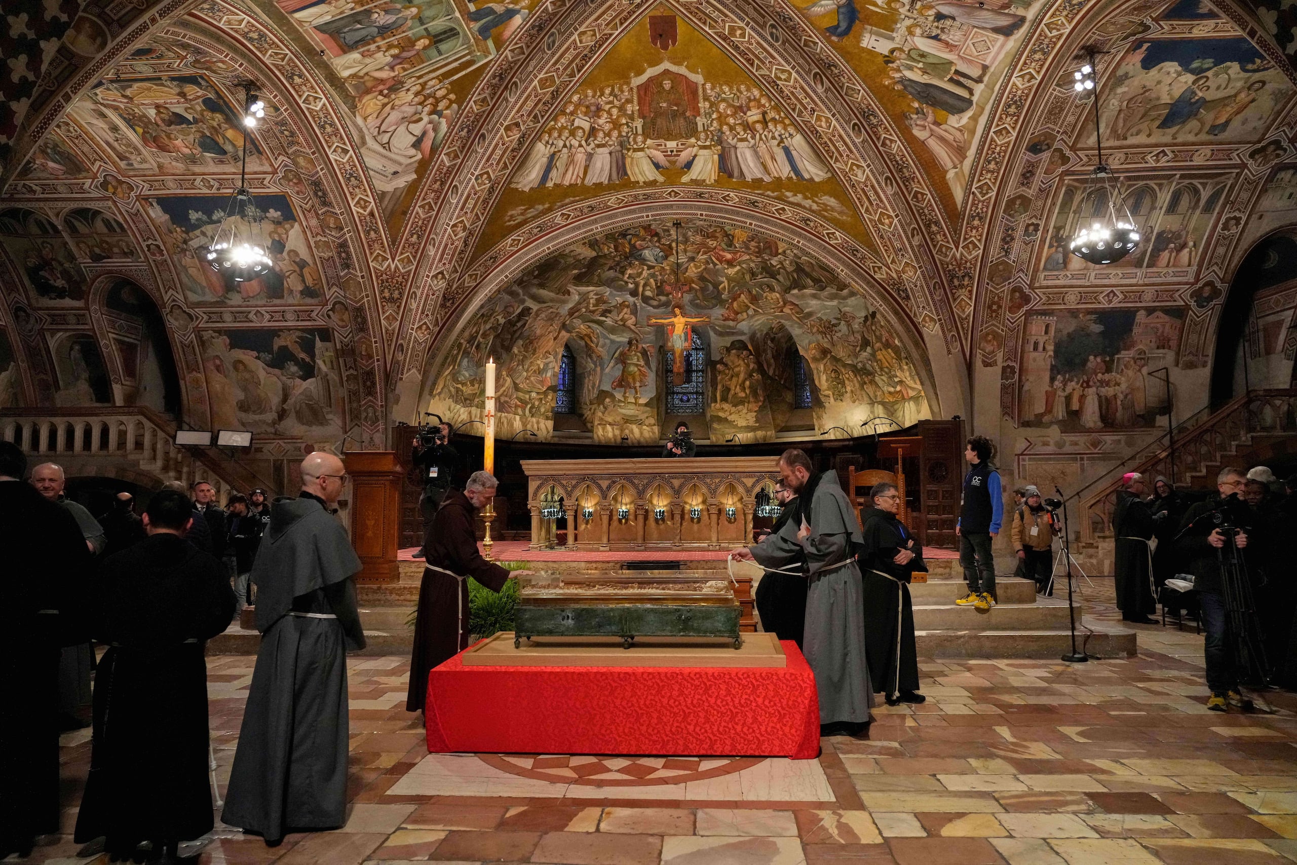 Frailes rezan ante los restos de Francisco de Asís en la Basílica de San Francisco de Asís, en Asís, Italia, el sábado 21 de febrero de 2026, en vísperas de una exposición pública que comenzará el 22 de febrero para conmemorar el 800 aniversario de su muerte en 1226. (Foto AP/Gregorio Borgia)