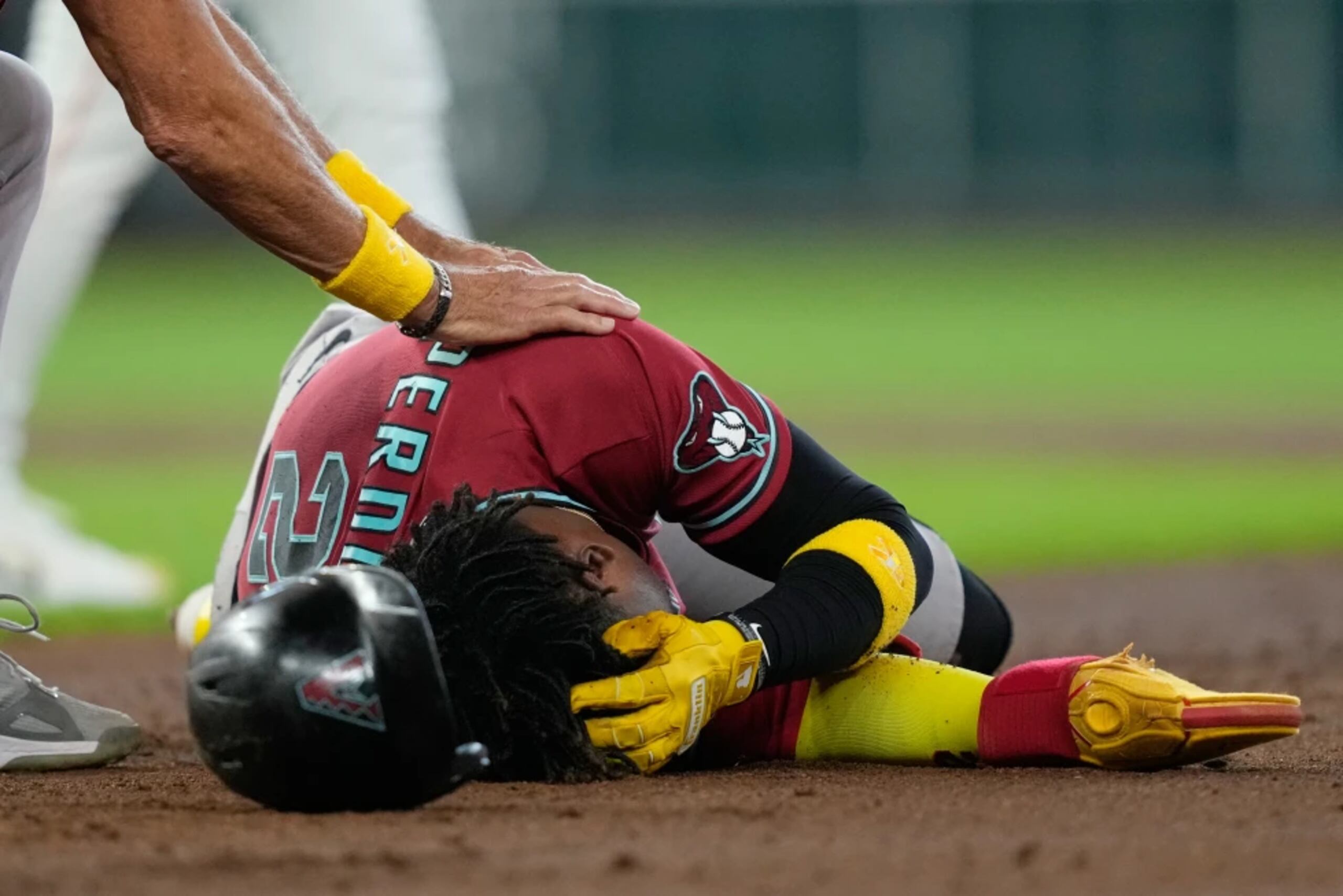 Gerardo Perdomo, de los Diamondbacks de Arizona, yace sobre el terreno.