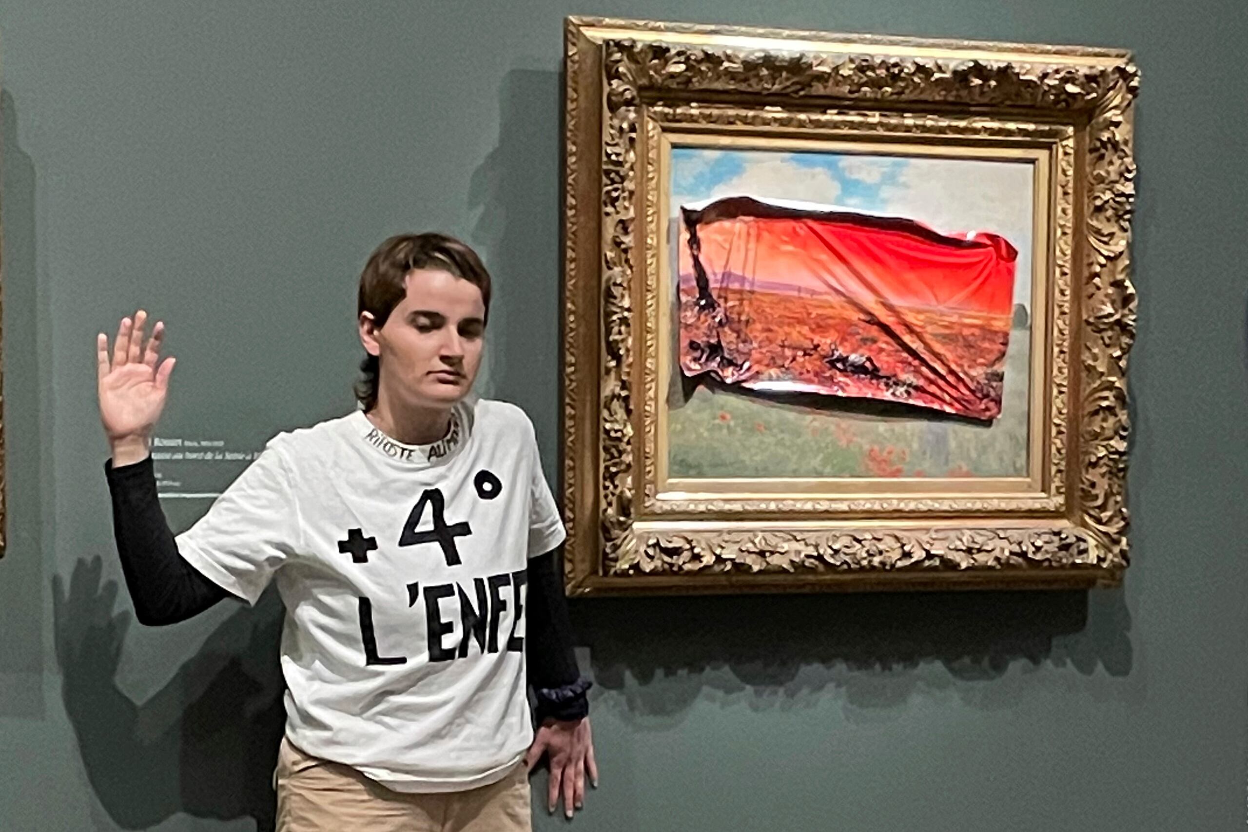 Una activista medioambiental posando junto al cuadro "Campo de amapolas" de Claude Monet en el Museo de Orsay, el sábado 1 de junio de 2024, en París. (Riposte Alimentaire vía AP)