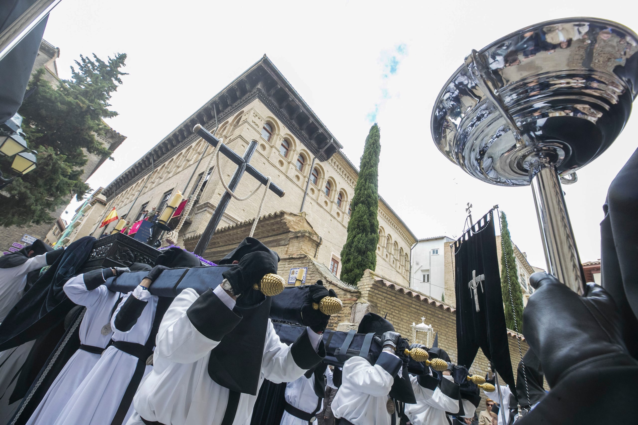 Miembros de la cofradía de la Exaltación de la Santa Cruz sacan el paso del palacio de la Real Maestranza de Caballería de Zaragoza (España) este Jueves Santo. EFE/Javier Cebollada