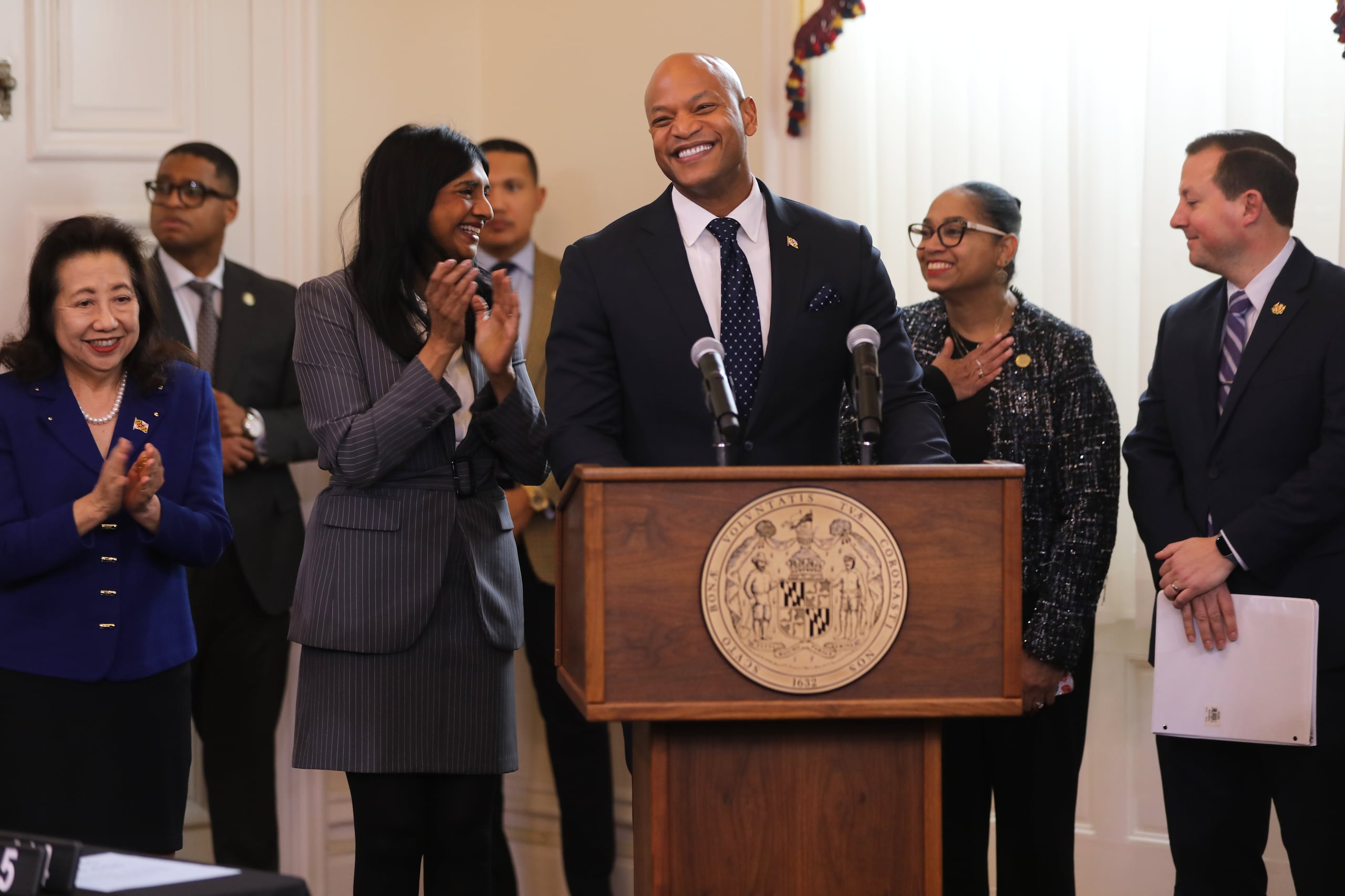 El gobernador de Maryland Wes Moore, centro, sonríe antes de firmar una legislación que prohíbe alcanzar acuerdos con agencias de aplicación de las leyes migratorias del gobierno federal durante una ceremonia de firma, el 17 de febrero de 2026, en Annapolis, Maryland. Lo acompañan, de izquierda a derecha, la secretaria de estado de Maryland Susan Lee, la vicegobernadora Aruna Miller, la presidenta de la Cámara Joseline Peña-Melnyk y el presidente del Senado, Bill Ferguson. (AP Foto/Brian Witte)