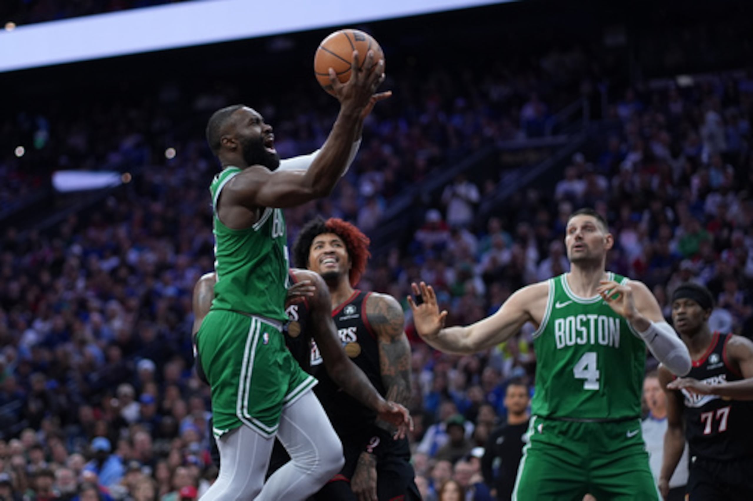 Jaylen Brown (izq.), de los Boston Celtics, se lanza a canasta ante Kelly Oubre Jr., de los Philadelphia 76ers.