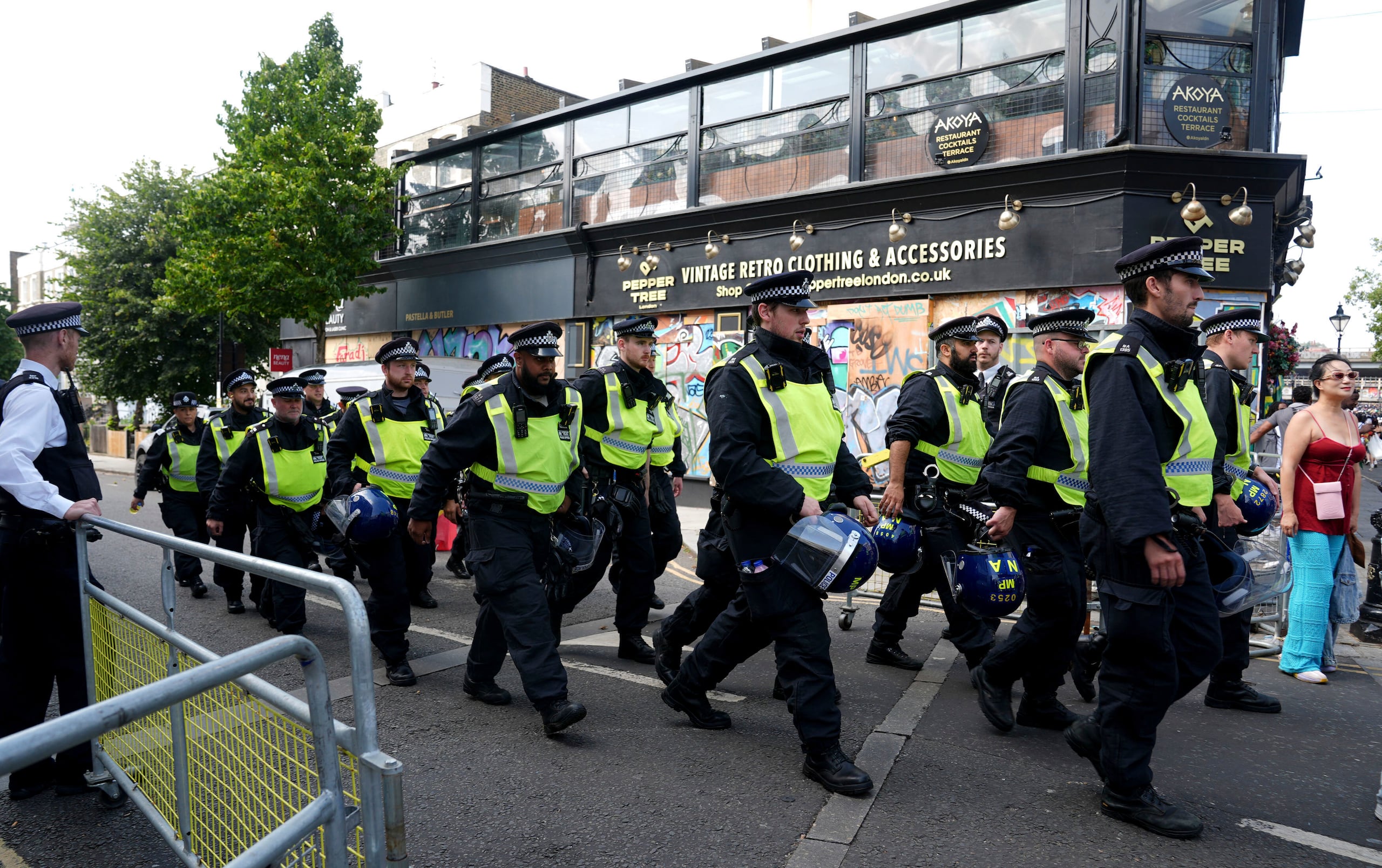 Policías recorren Ladbroke Grove durante el carnaval de Notting Hill en el oeste de Londres, el lunes 26 de agosto de 2024. (Lucy North/PA vía AP)