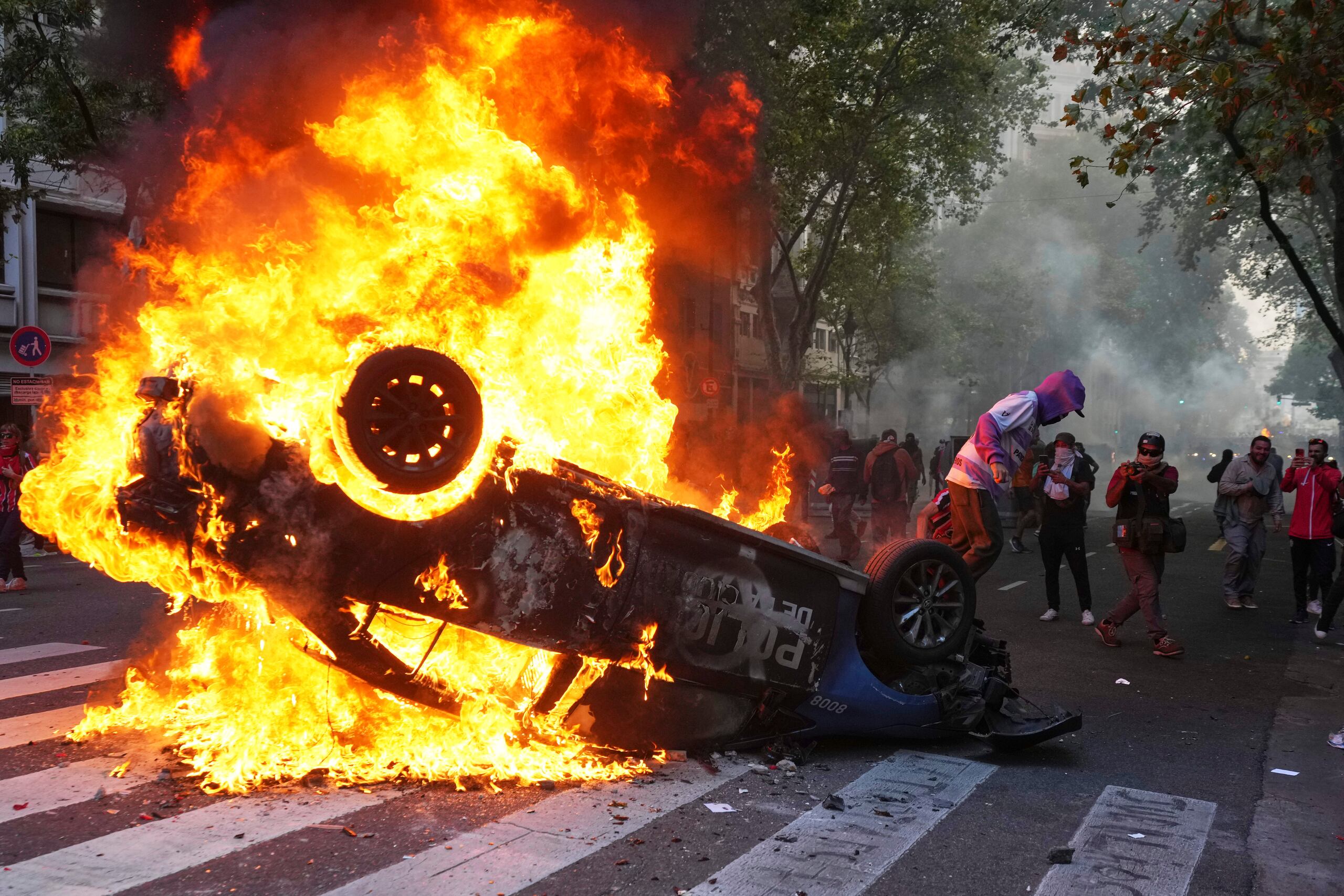 Un manifestante quema un coche patrulla durante una manifestación de hinchas de fútbol y jubilados que exigen pensiones más altas y se oponen a las medidas de austeridad implementadas por el gobierno de Javier Milei en Buenos Aires, Argentina.