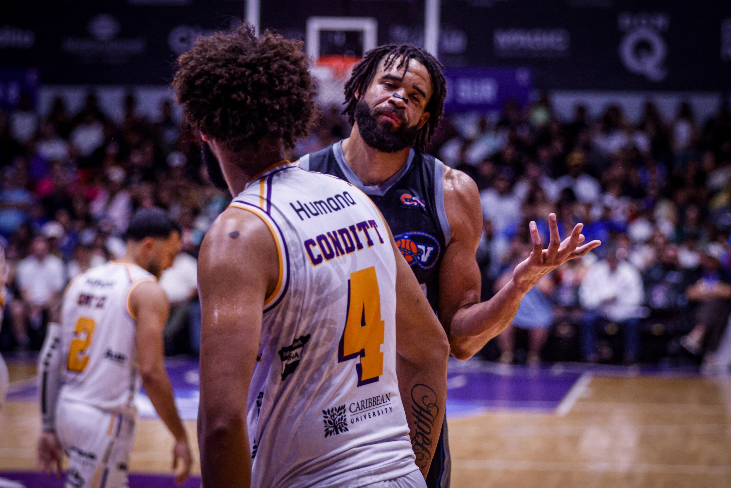 JaVale McGee, refuerzo de los Vaqueros de Bayamón, celebra frente a George Conditt IV, de los Gigantes de Carolina-Canóvanas.