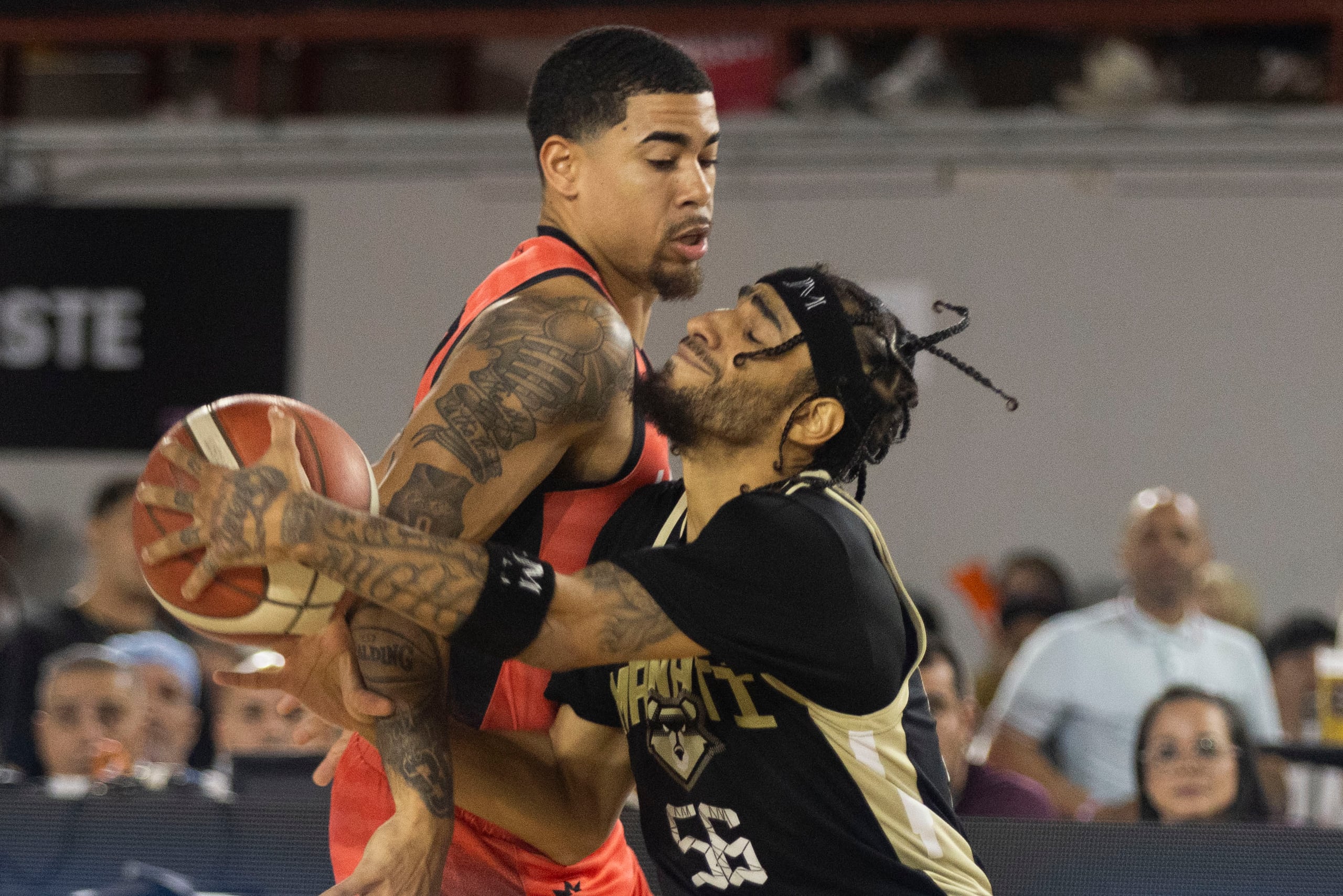 Jhivvan Jackson, de los Osos de Manatí, choca con Christian Pizarro, de los Criollos de Caguas, en el séptimo juego de la final 2024 del BSN.