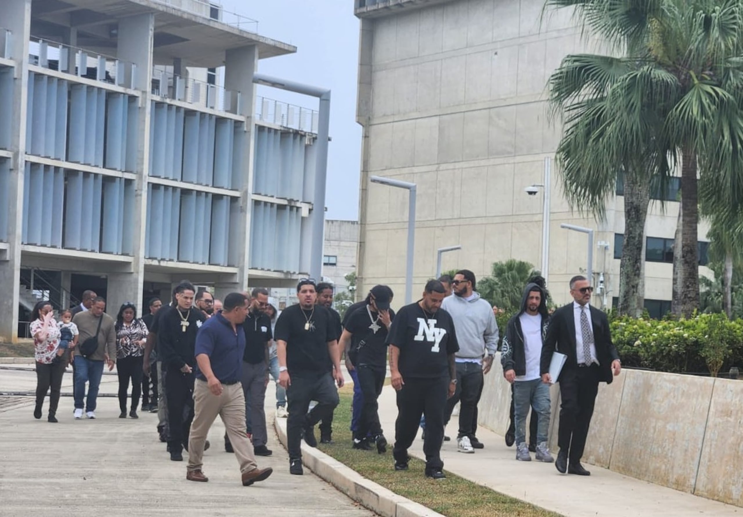 El abogado de Yovngchimi, Saam Zangeneh (vestido de traje y corbata), sale del Tribunal federal, seguido de familiares y amigos de Yovngchimi.