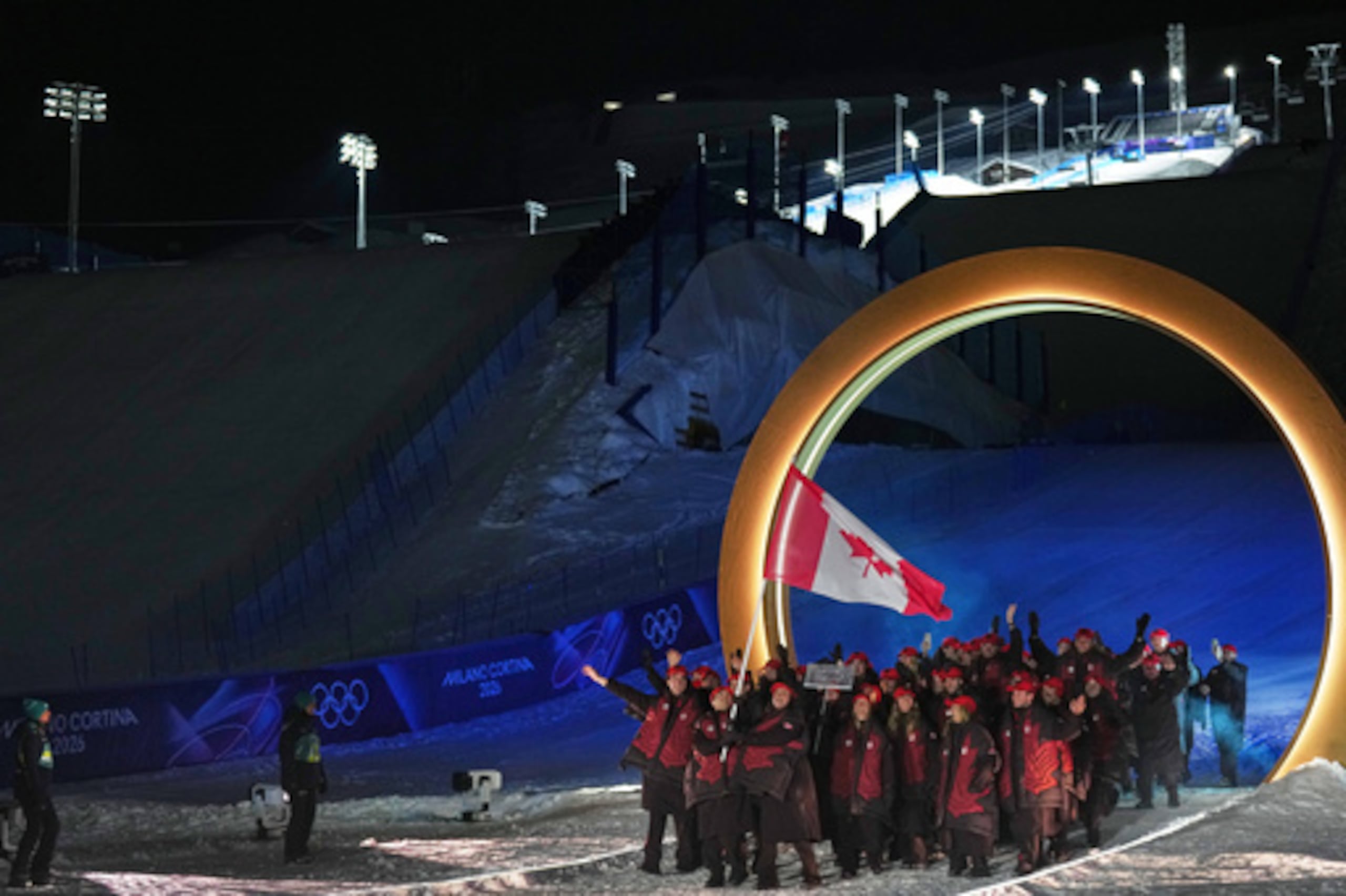 Marielle Thompson y Mikael Kingsbury, abanderados de Canadá, caminan con los atletas durante la ceremonia de apertura de los Juegos Olímpicos de Invierno de 2026, en Livigno, Italia, el viernes 6 de febrero de 2026. (AP Photo/Abbie Parr)