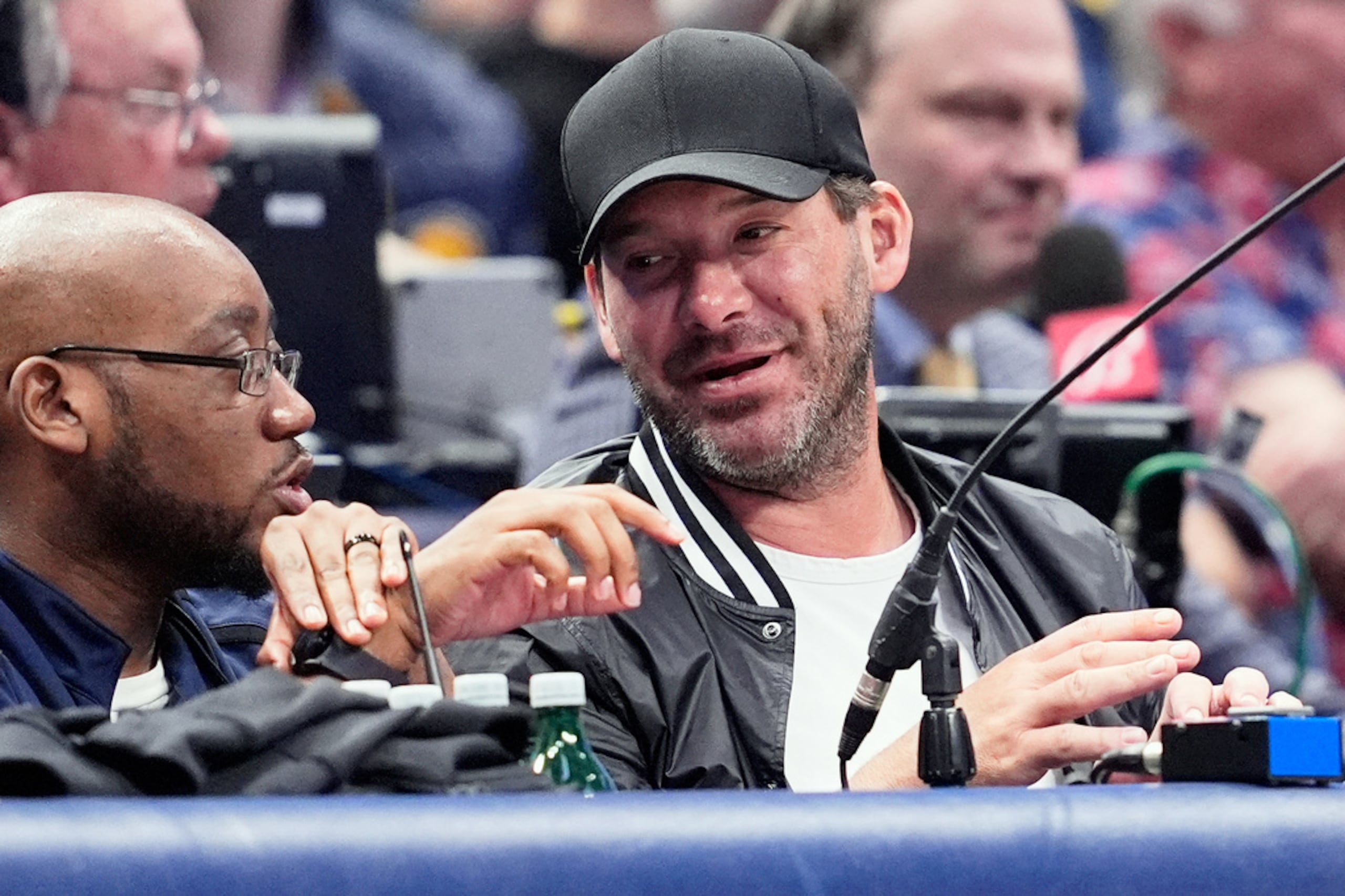 Tony Romo, derecha, exquarterback de los Cowboys de Dallas, y analista de NFL en CBS, asiste a un partido de baloncesto de la NBA entre los Pacers de Indiana y los Mavericks de Dallas, el 5 de marzo de 2024, en Dallas.