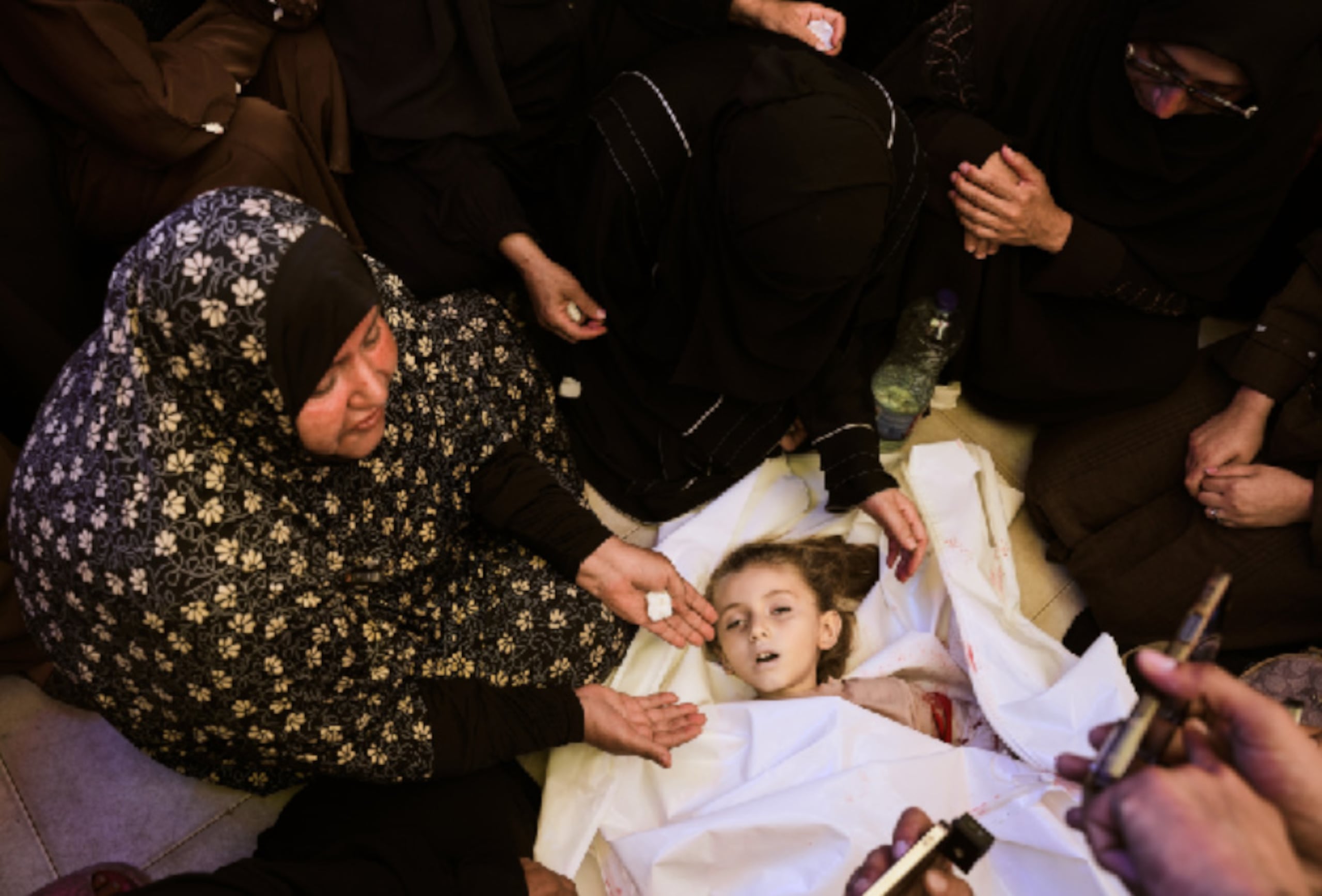 Familiares en duelo rodean el cuerpo de Menna Allah Abu Labda, una niña palestina de 6 años que murió en un ataque aéreo israelí, durante su funeral en el Hospital Nasser, el lunes 25 de mayo de 2026, en Jan Yunis, Franja de Gaza. (AP Foto/Abdel Kareem Hana)