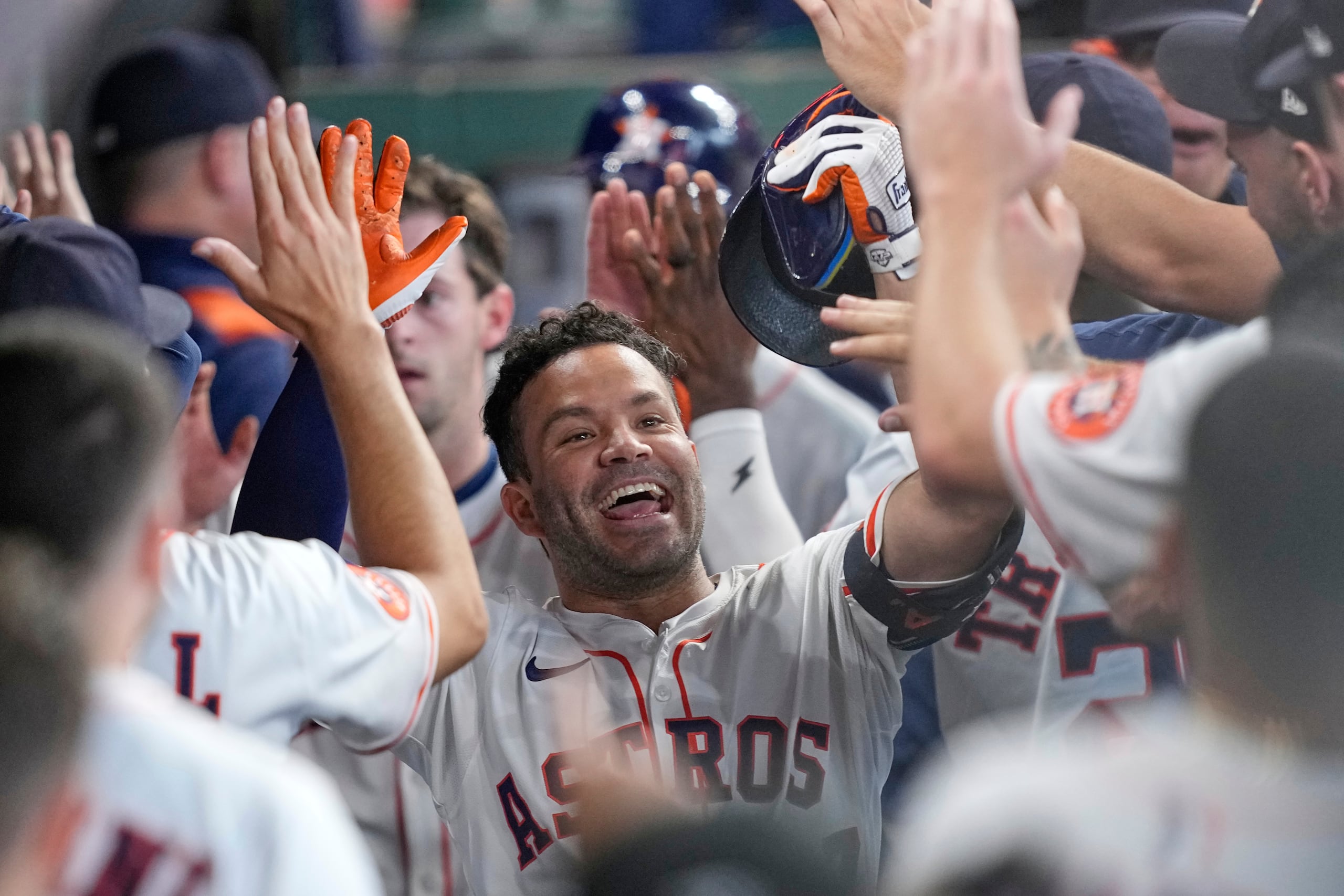 José Altuve de los Astros de Houston celebra en el dugout después de batear un jonrón de tres carreras contra los Nacionales de Washington durante la segunda entrada de un partido de béisbol el miércoles 30 de julio de 2025, en Houston. (AP Photo/David J. Phillip)