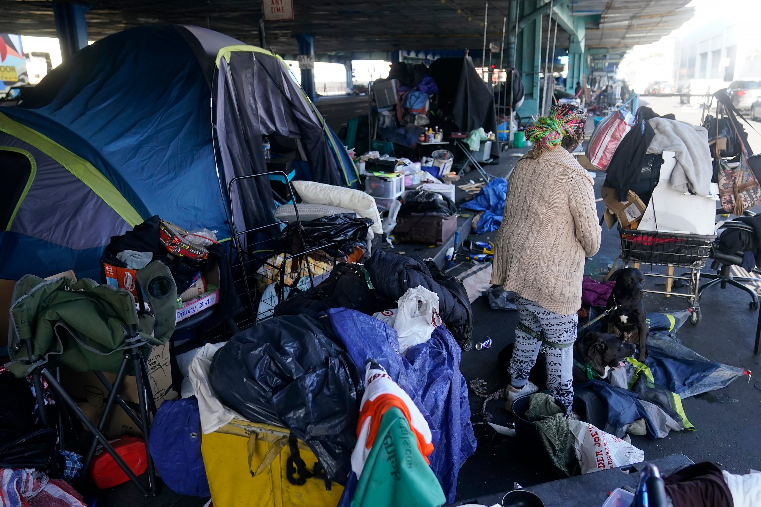 Una mujer recoge sus pertenencias antes de las tareas de retiro de un campamento de desamparados en San Francisco, el 29 de agosto de 2023. (AP Foto/Jeff Chiu, Archivo)