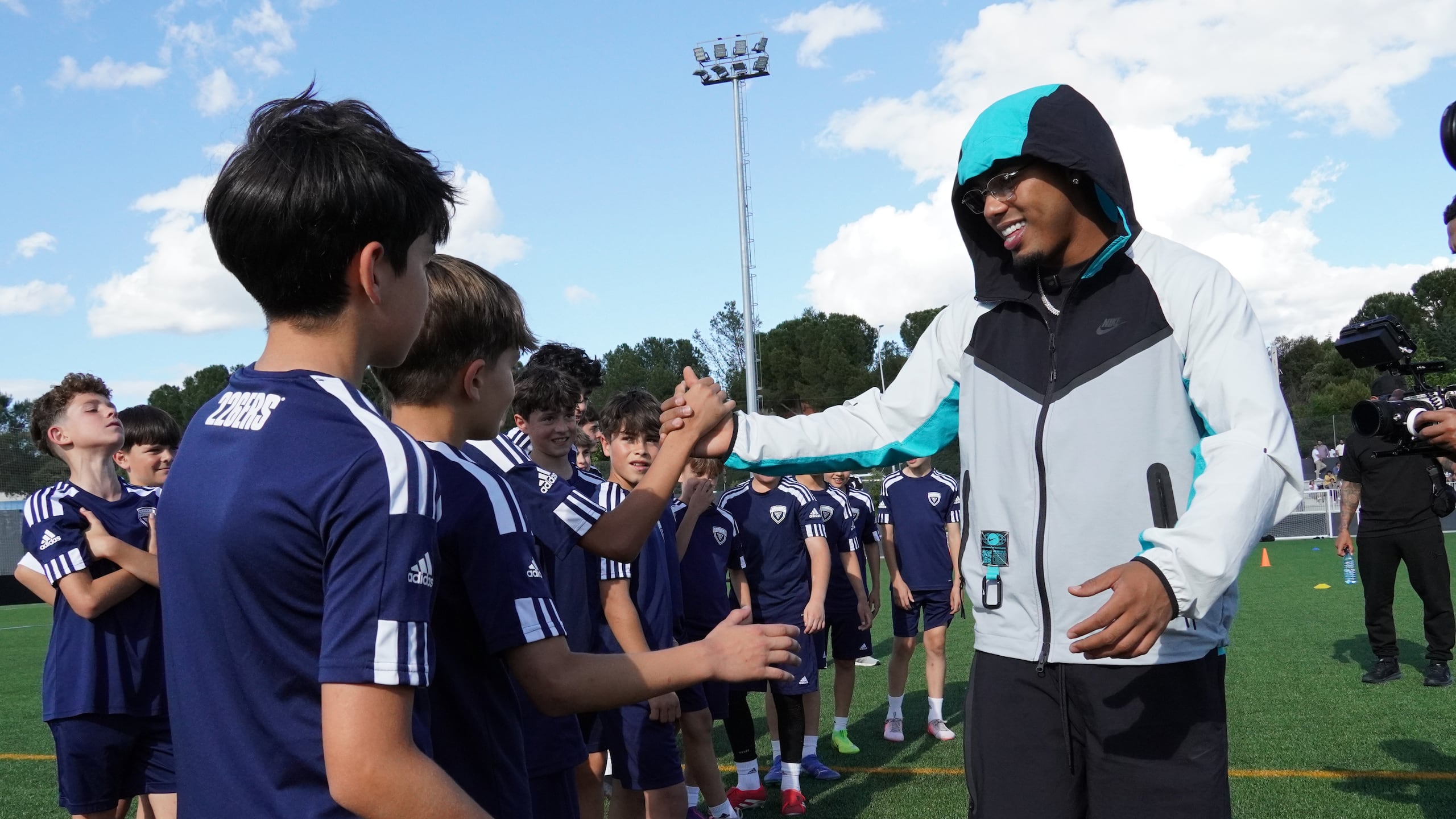 Myke Towers durante un encuentro con jóvenes que reciben clínicas de fútbol.