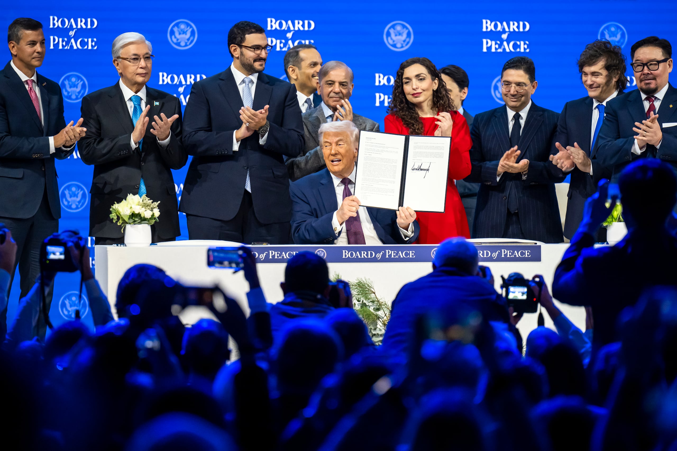 El presidente de Estados Unidos, Donald Trump, (centro) muestra la carta en la que se ha firmado la iniciativa Junta de Paz, rodeado de un grupo de líderes mundiales, durante la semana en la que se celebra el Foro de Davos. EFE/EPA/GIAN EHRENZELLER