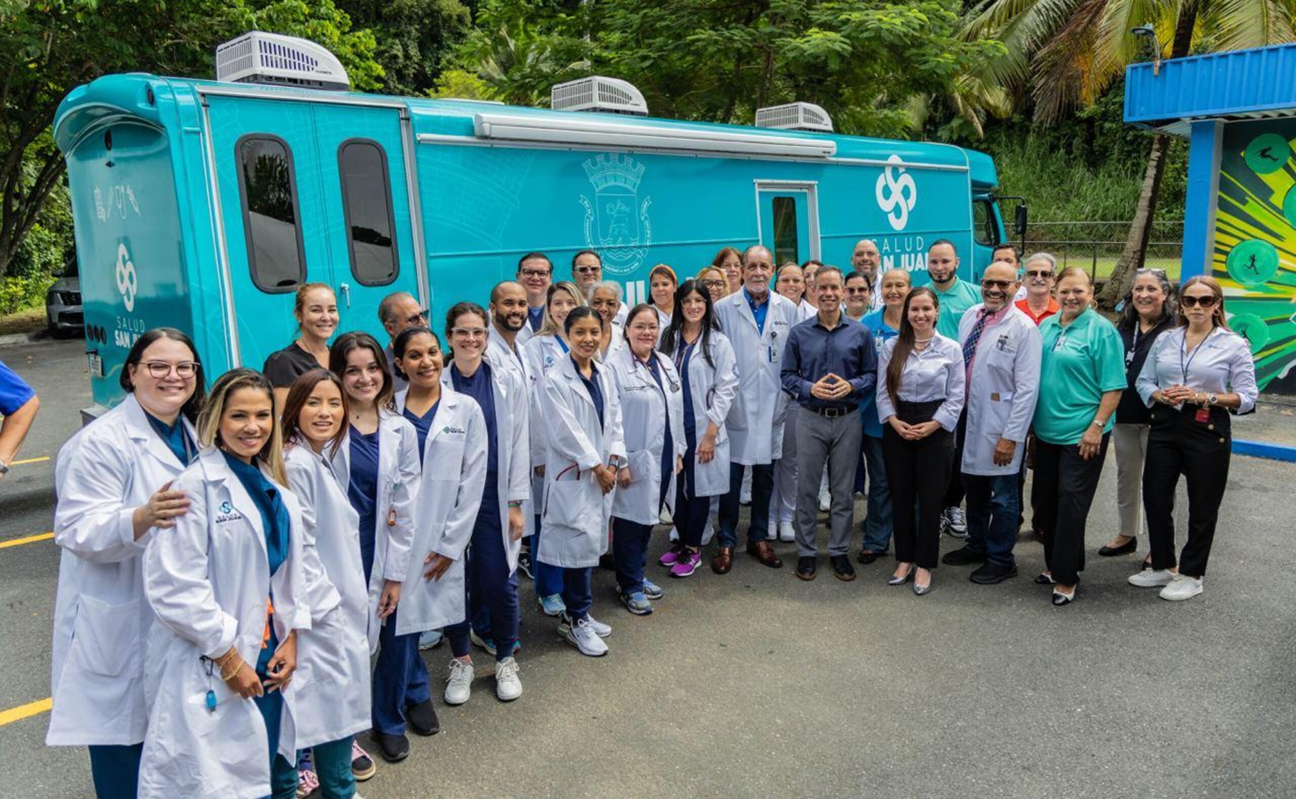 El alcalde Miguel Romero y personal del municipio posa frente a una de las unidades móviles.