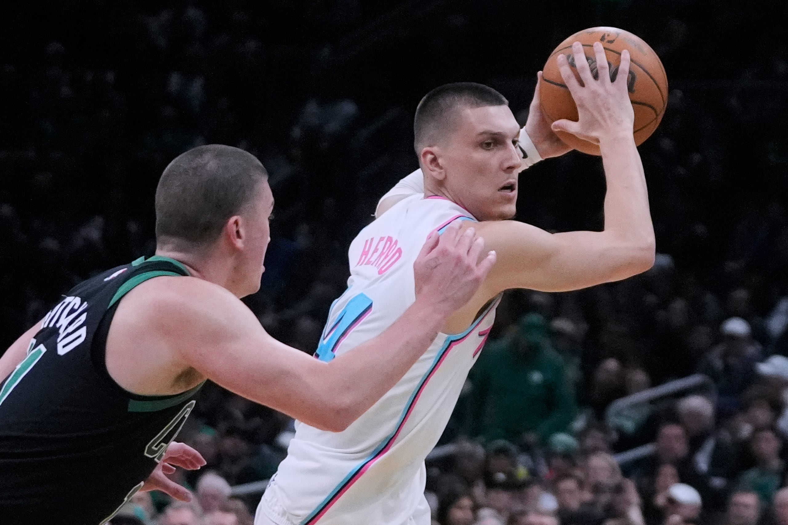 Tyler Herro, base del Heat de Miami, busca enviar un pase frente a Payton Pritchard, de los Celtics de Boston, el miércoles 2 de abril de 2025 (AP Foto/Charles Krupa)