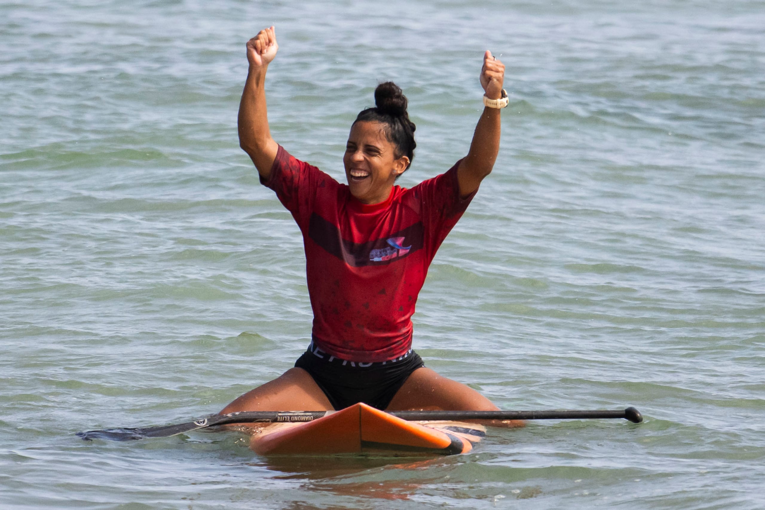 Mariecarmen Rivera celebra en la playa Encuentro su oro en SUP Surf.