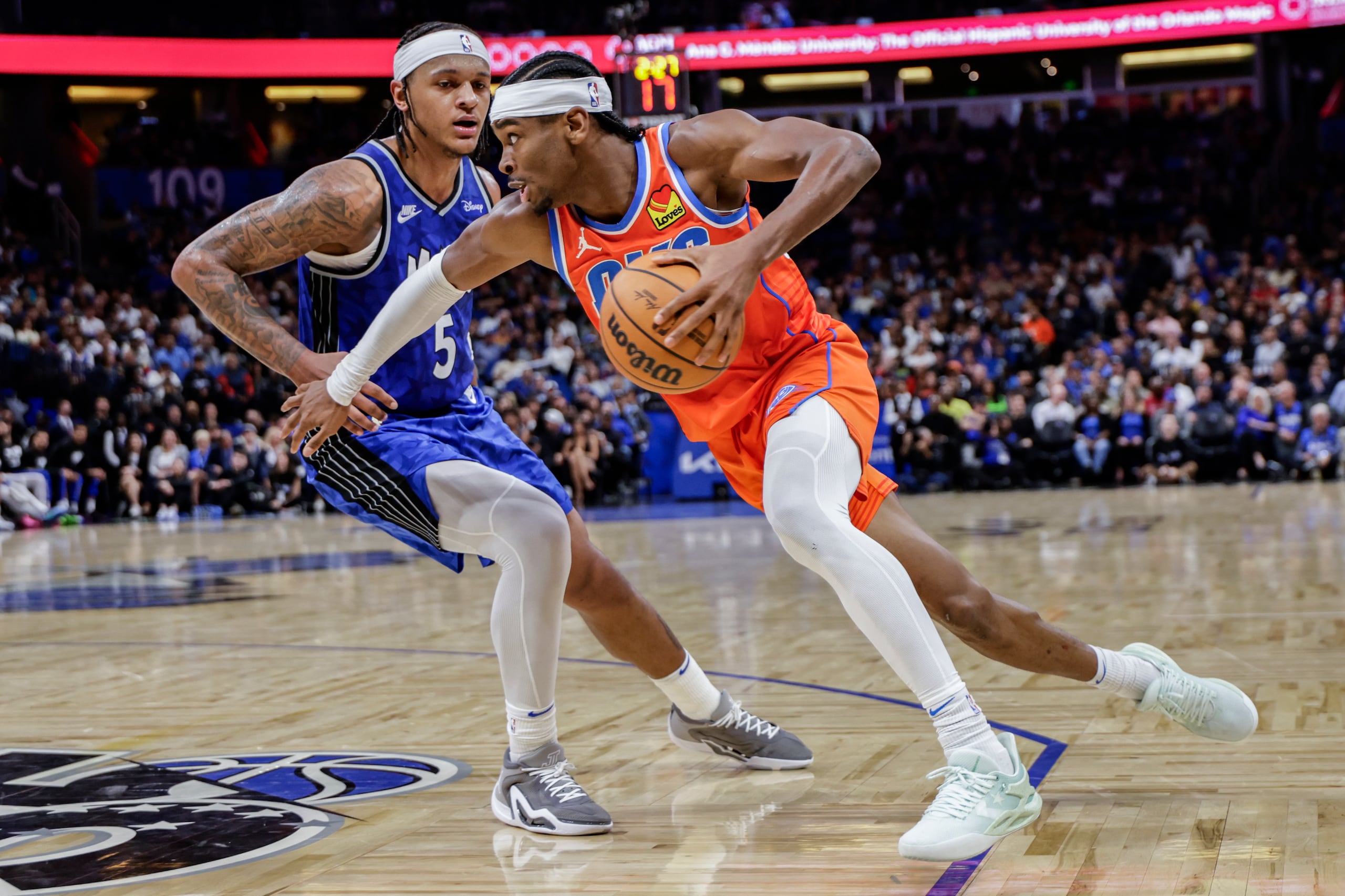 Shai Gilgeous-Alexander maneja el balón frente a la defensa de Paolo Banchero, del Magic de Orlando.