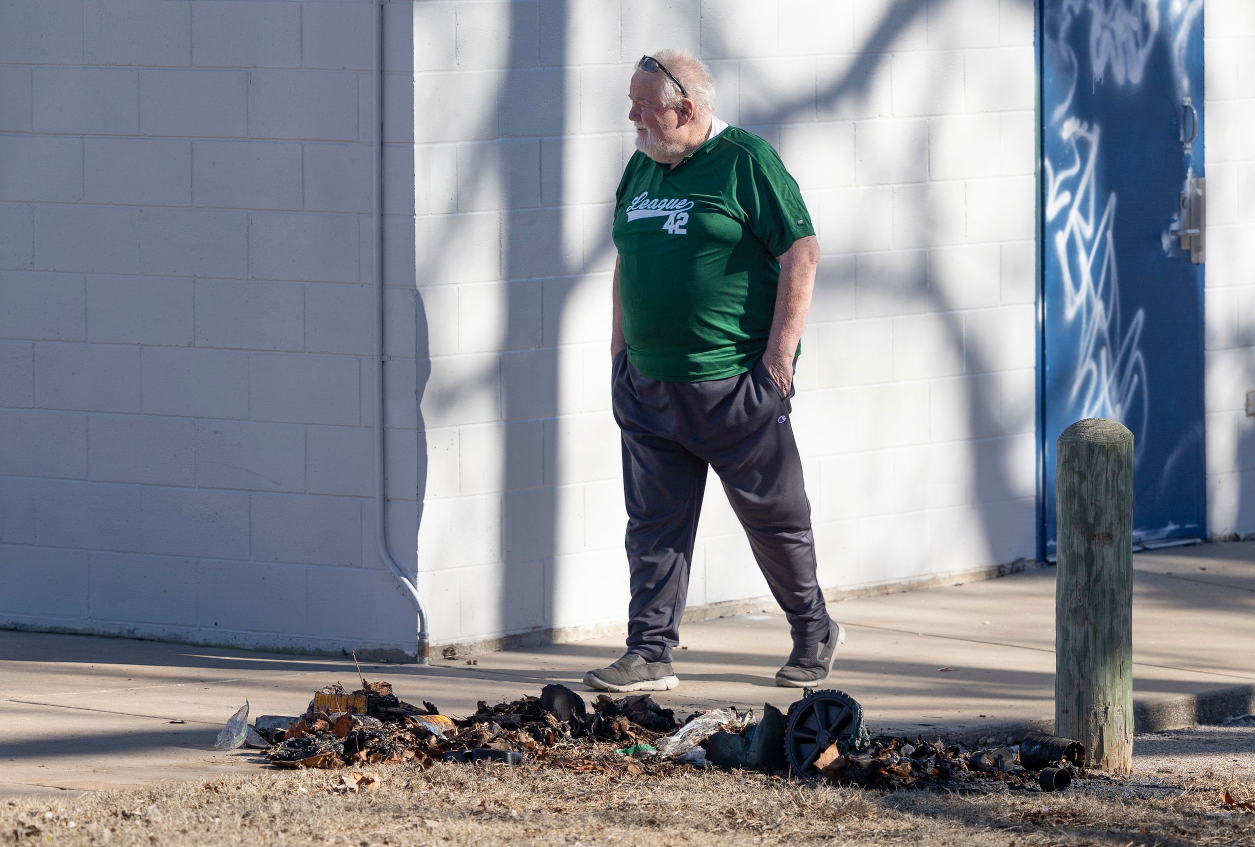 Bob Lutz, director ejecutivo de Liga 42, una liga de béisbol juvenil en Wichita, Kansas, camina junto a los restos carbonizados de un contenedor de basura donde la policía de Wichita encontró piezas de una estatua robada de Jackie Robinson el martes 30 de enero de 2024. La estatua de tamaño natural de Jackie Robinson fue cortada por los tobillos del campo de béisbol de la Liga 42 el 25 de enero. La policía no ha realizado arrestos en el caso, pero dijo el martes que la estatua estaba dañada sin posibilidad de reparación. (Travis Heying/The Wichita Eagle vía AP)