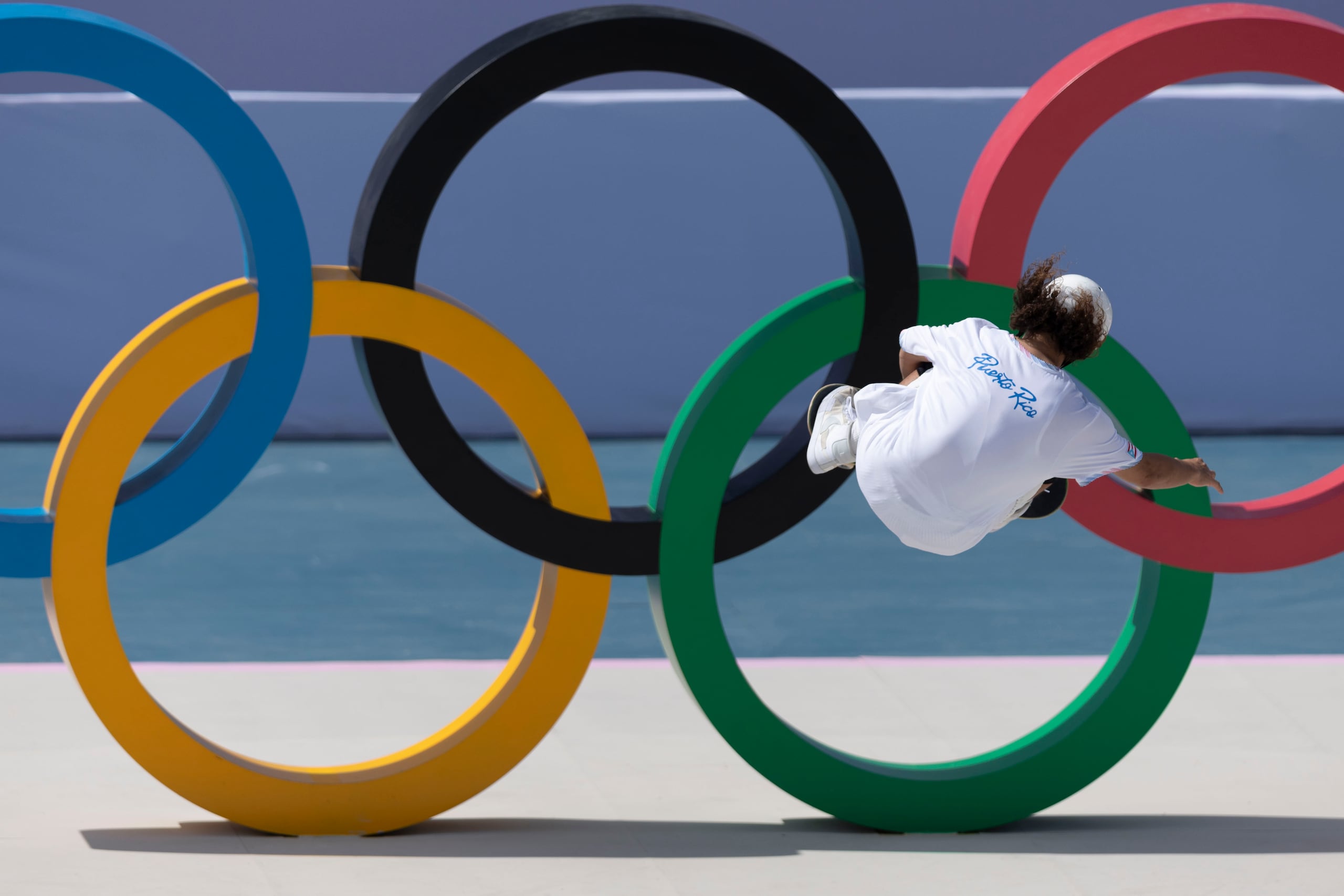 Steven Piñeiro hace una de sus piruetas al frente de los aros olímpicos que hace reconocer la pista como la de los Juegos Olímpicos París 2024.