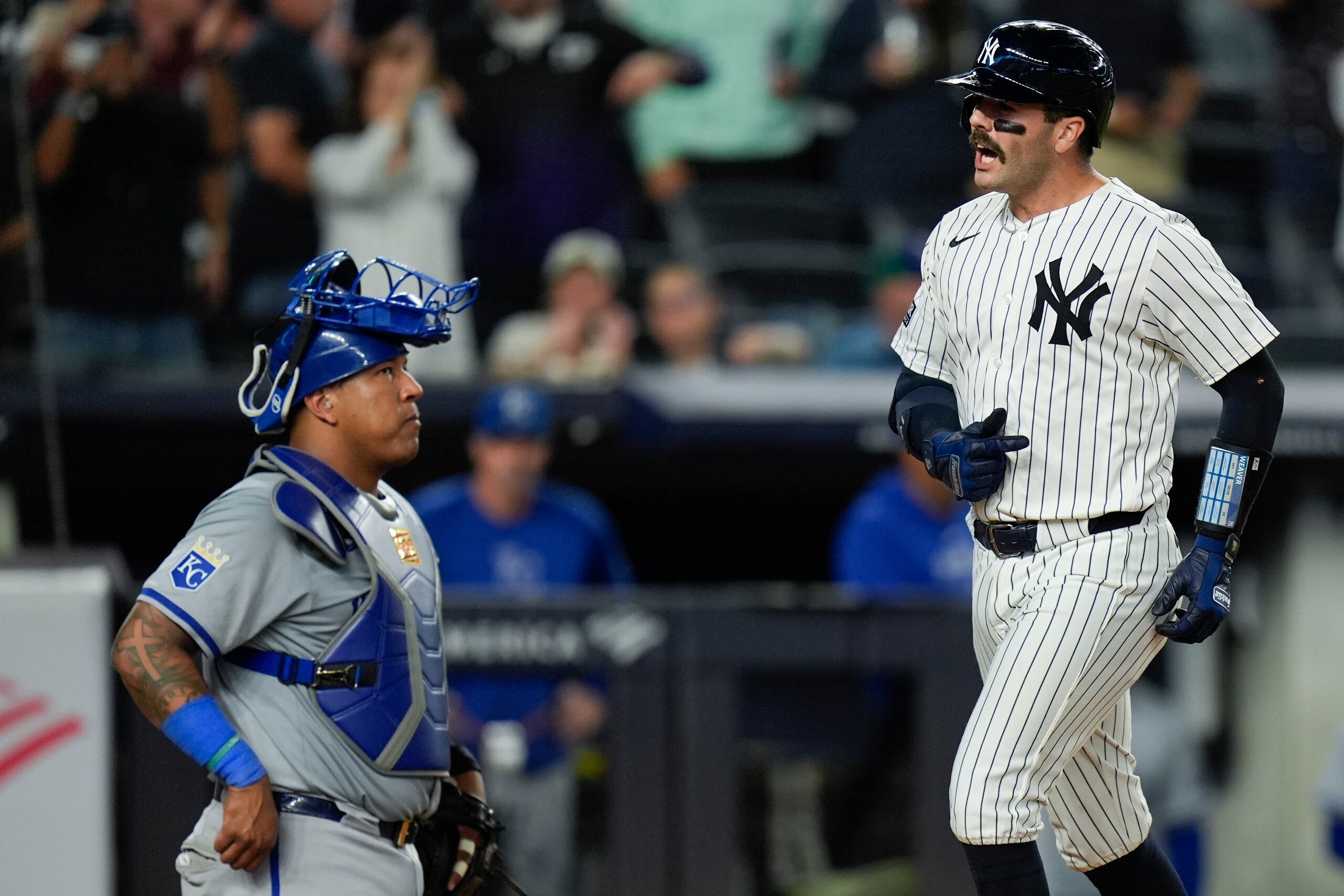 El receptor venezolano de los Reales de Kansas City, Salvador Pérez (izquierda), observa, mientras Austin Wells (derecha), de los Yankees de Nueva York cruza el plato tras conectar un jonrón de tres carreras durante la séptima entrada del juego de béisbol en el Yankee Stadium, el lunes 9 de septiembre de 2024, en Nueva York. (AP Foto/Seth Wenig)