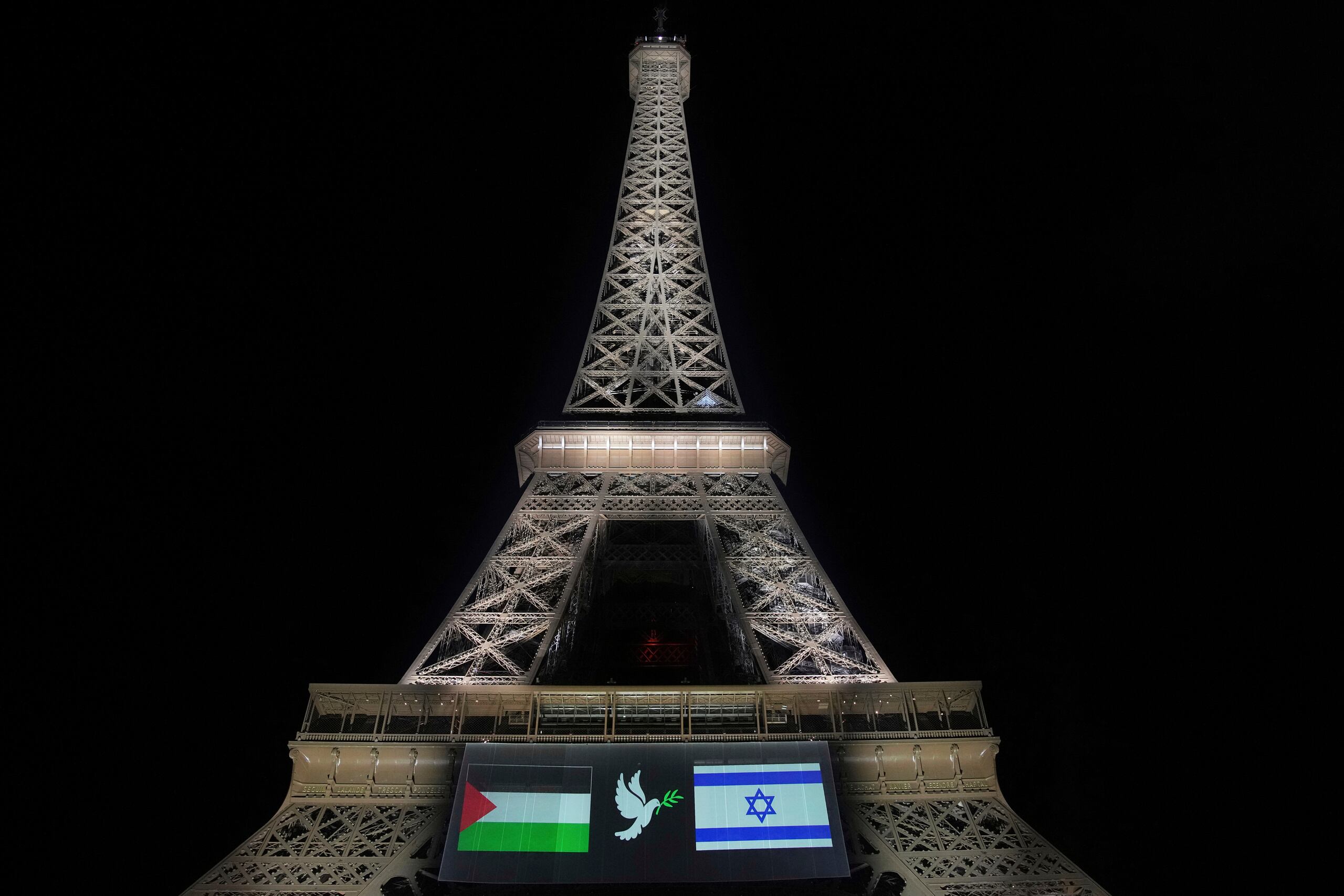 Una gran pantalla muestra las banderas israelí y palestina junto a una paloma en la torre Eiffel, el domingo 21 de septiembre de 2025, en París, mientras Francia se prepara para reconocer formalmente un Estado palestino en la Asamblea General de las Naciones Unidas. (AP Foto/Christophe Ena)